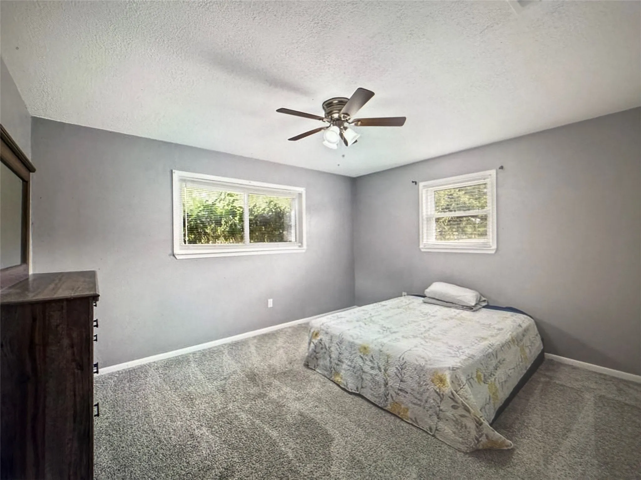 Bedroom featuring carpet flooring, ceiling fan, and a textured ceiling
