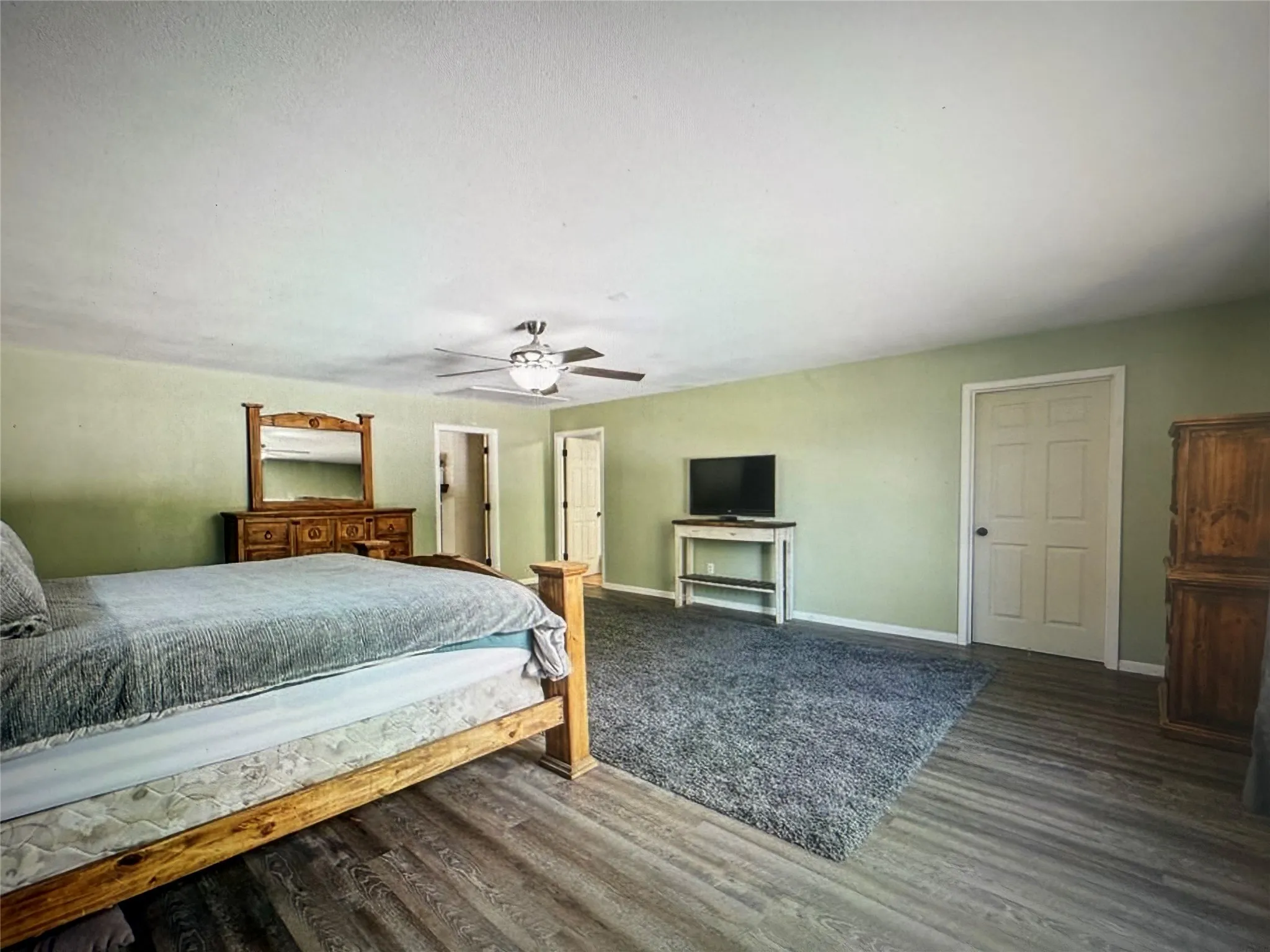 Bedroom featuring ceiling fan and dark wood-style floors