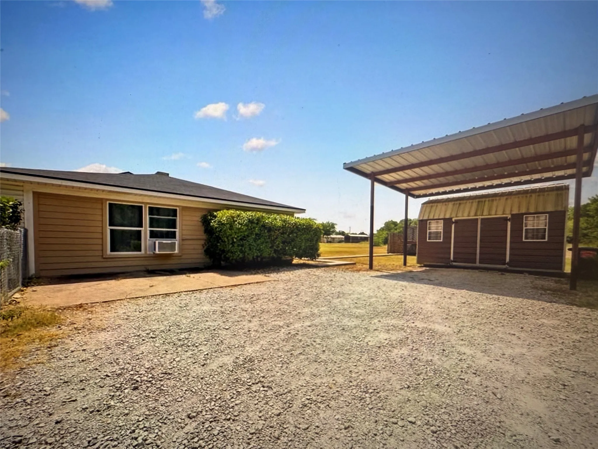View of yard featuring driveway, an outdoor structure, and a carport