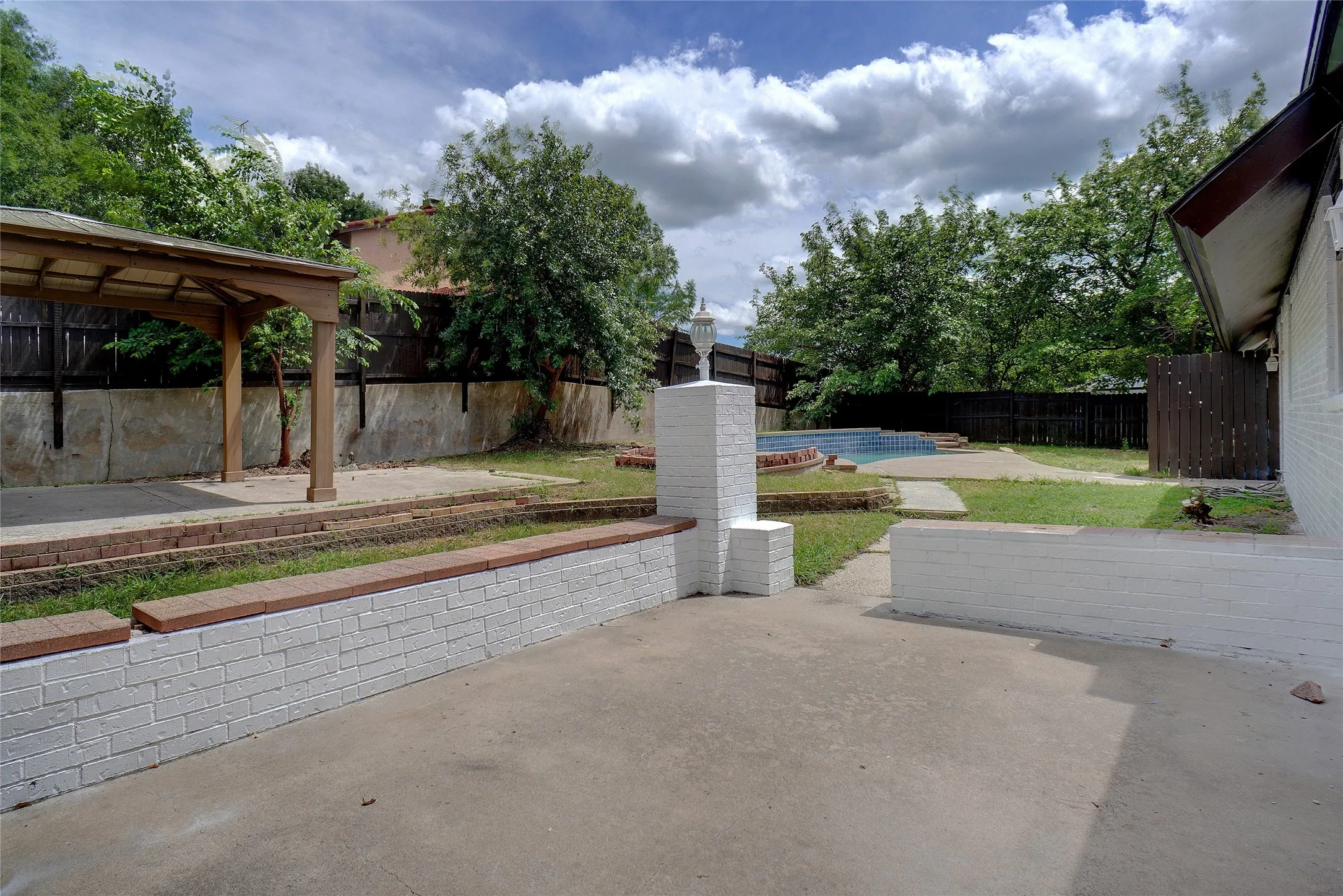 Fenced backyard featuring a patio area and a gazebo