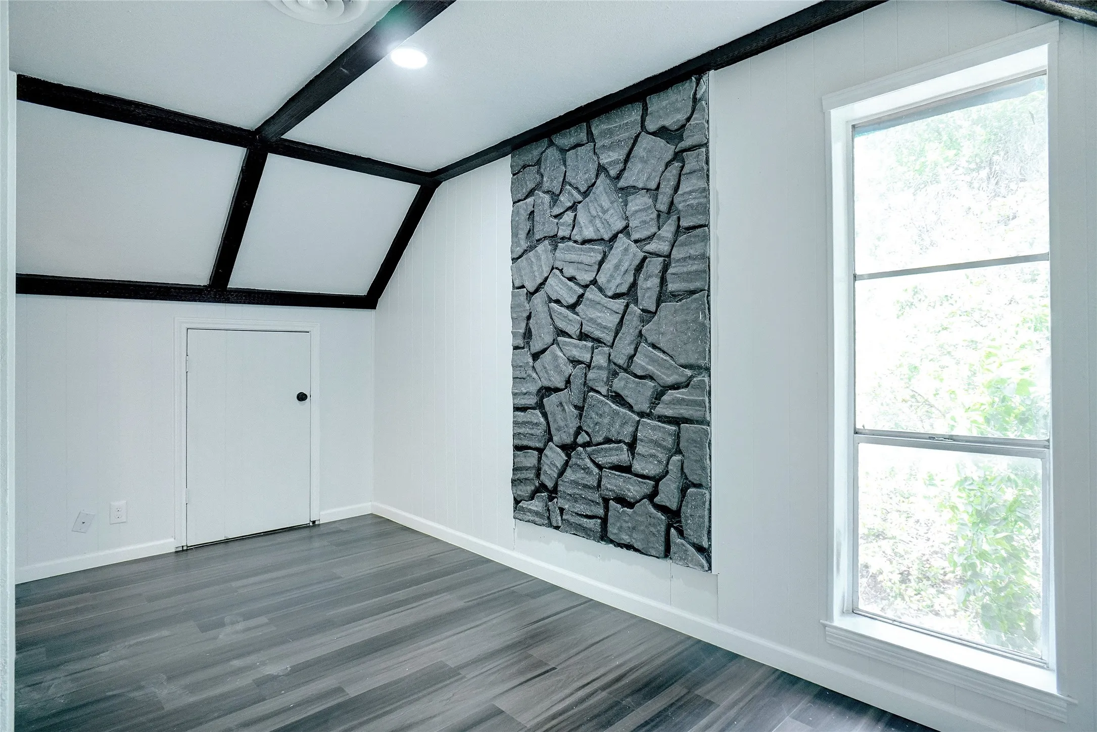 Additional living space featuring baseboards and wood finished floors