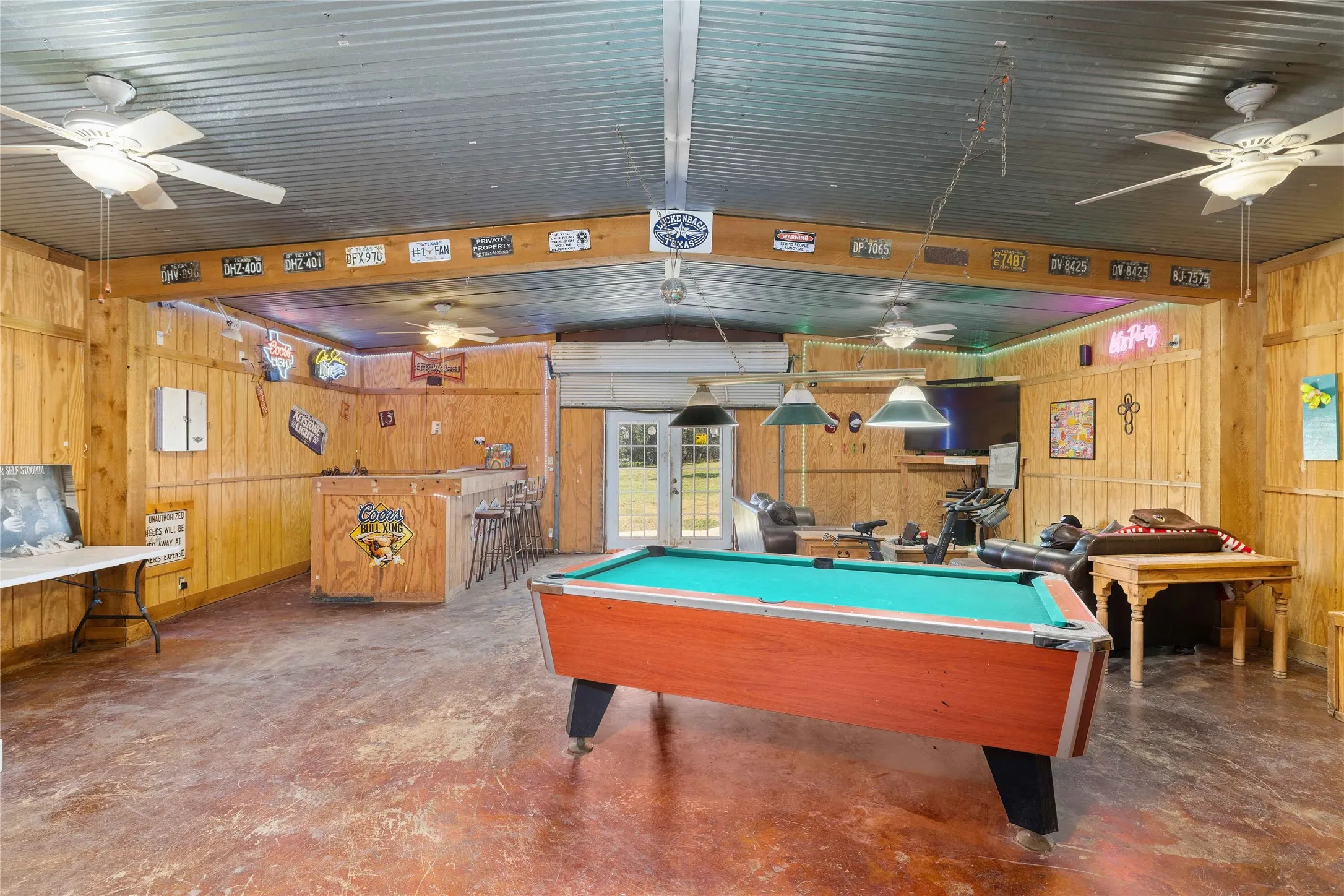 Game room featuring billiards table, finished concrete floors, wooden walls, ceiling fan, and lofted ceiling