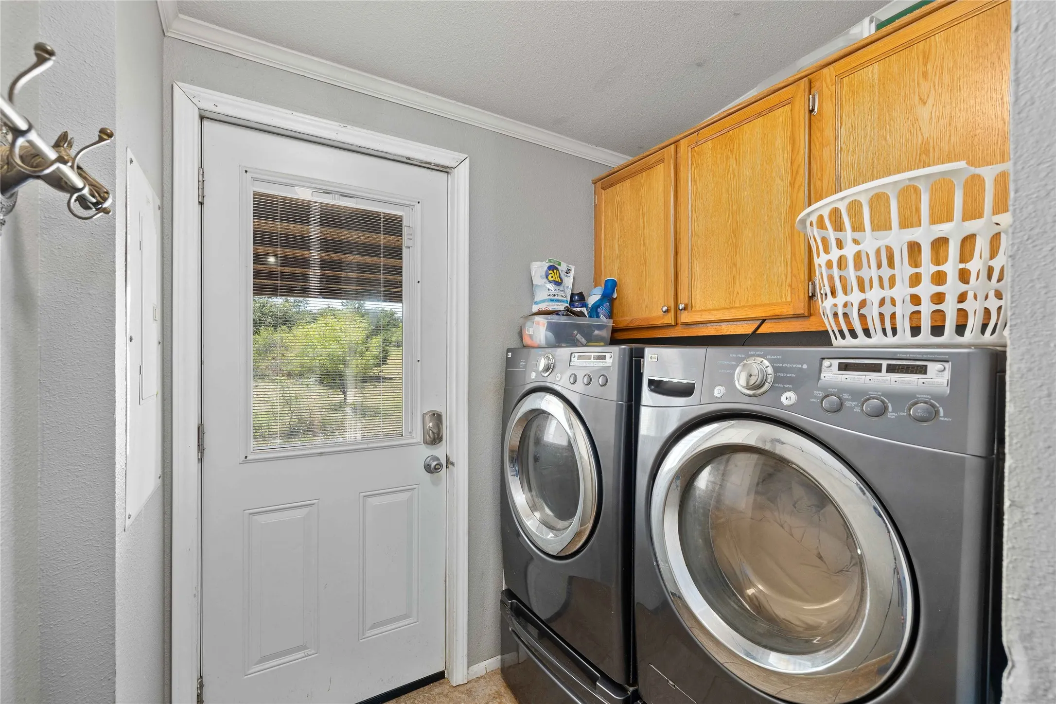 Laundry room with crown molding, cabinet space, and washing machine and clothes dryer