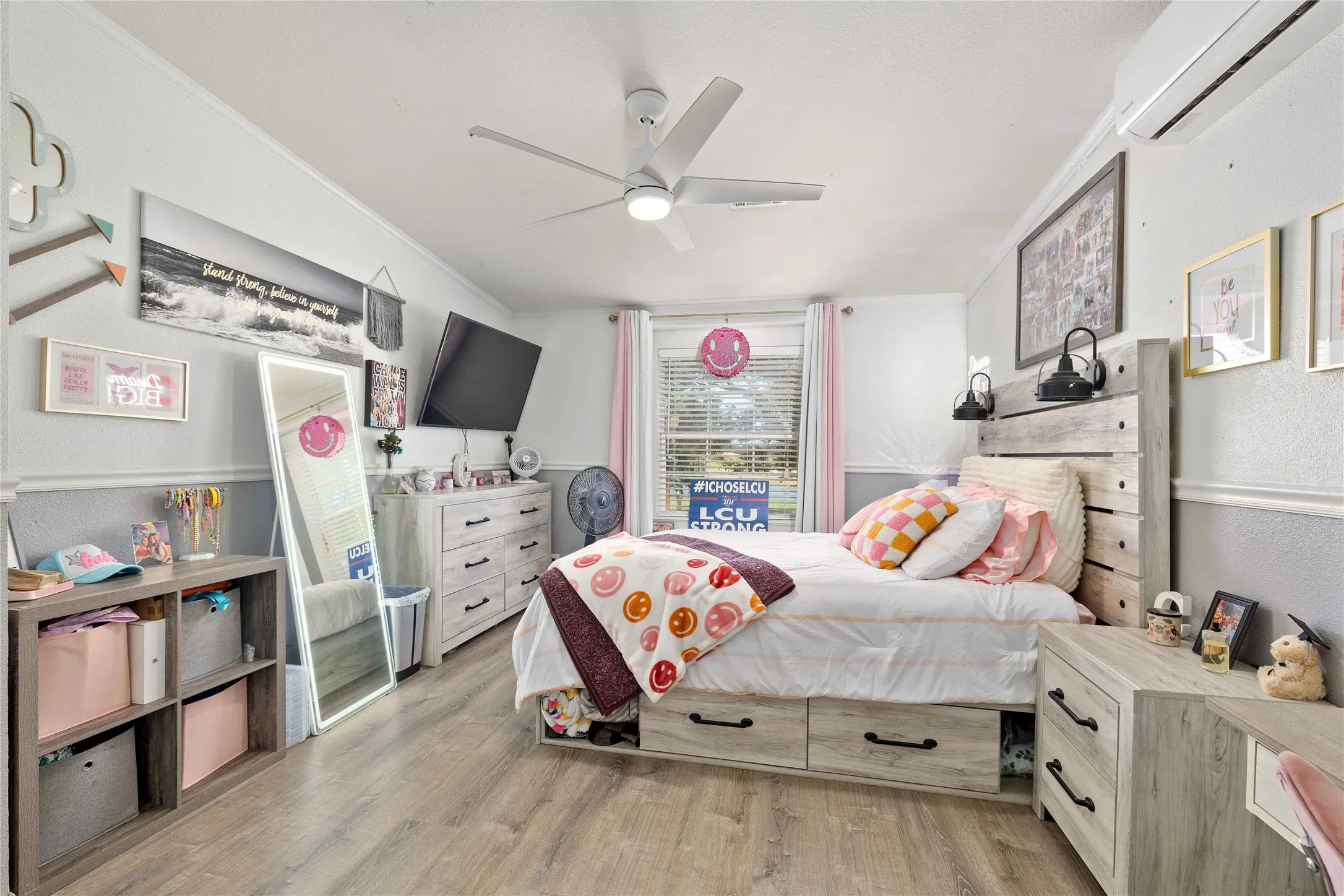 Bedroom featuring a wall mounted AC, light wood-type flooring, ornamental molding, ceiling fan, and a textured wall