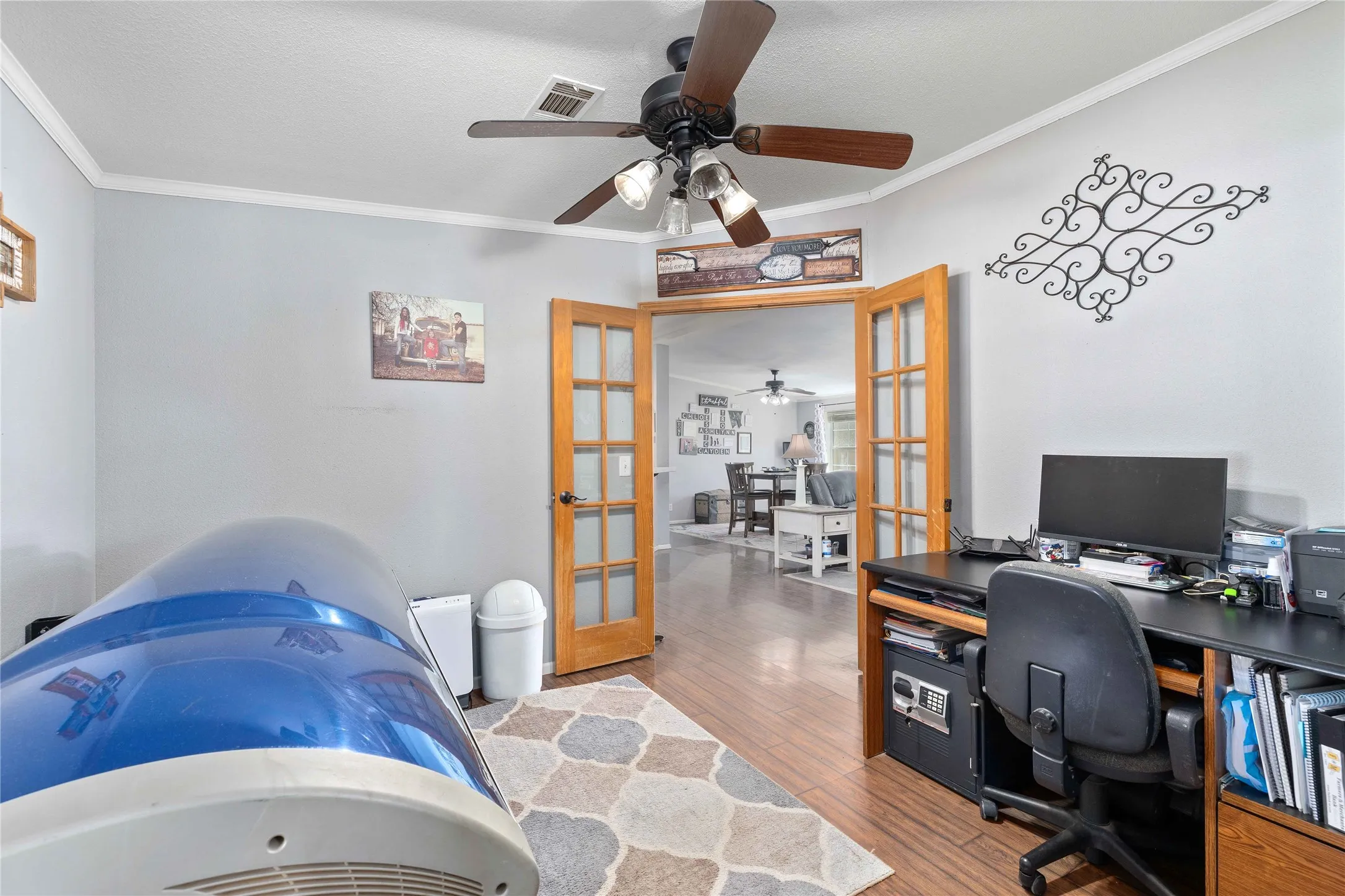 Office area with french doors, crown molding, wood finished floors, and ceiling fan