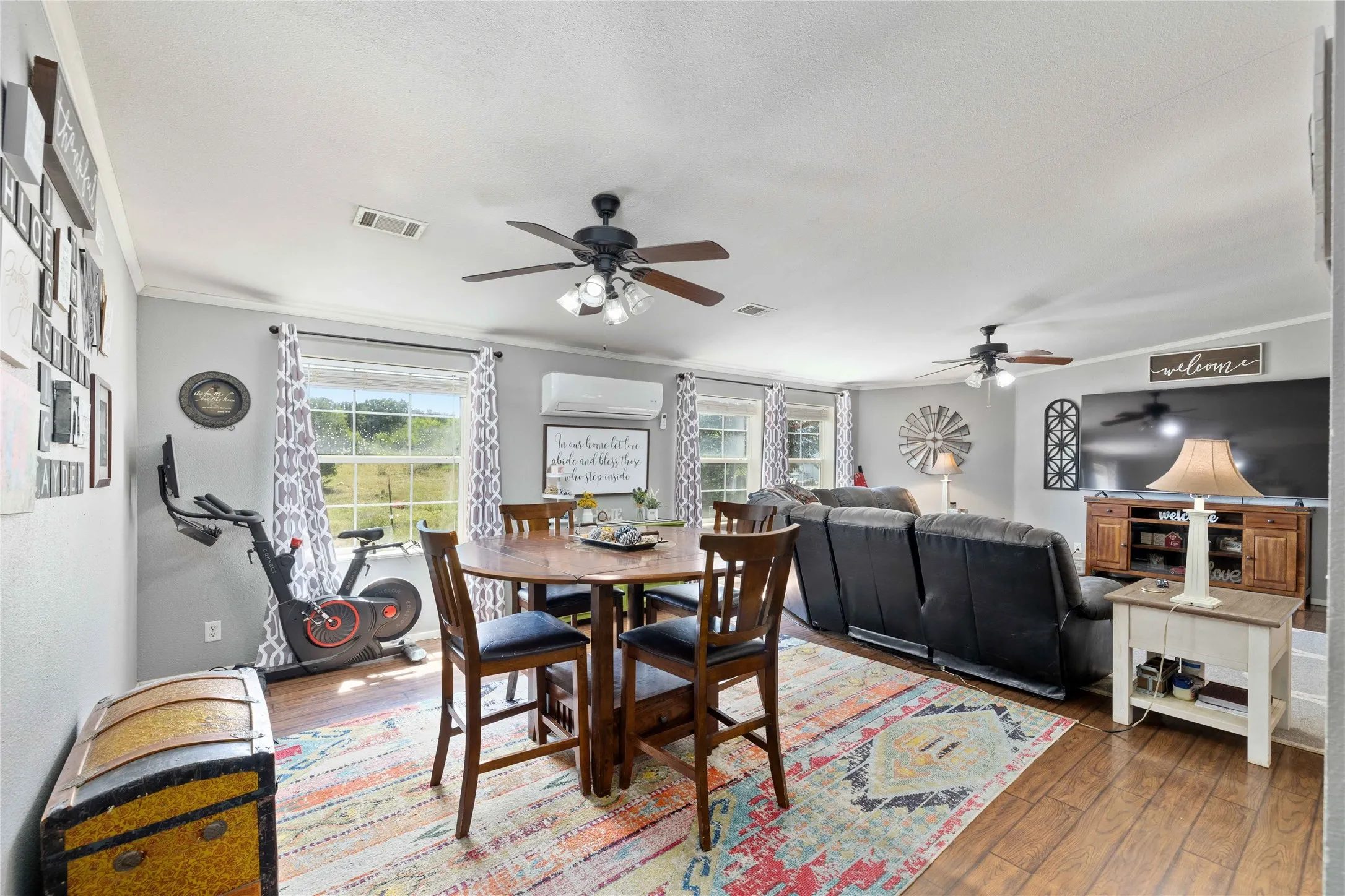 Dining area with crown molding, hardwood / wood-style flooring, an AC wall unit, and ceiling fan