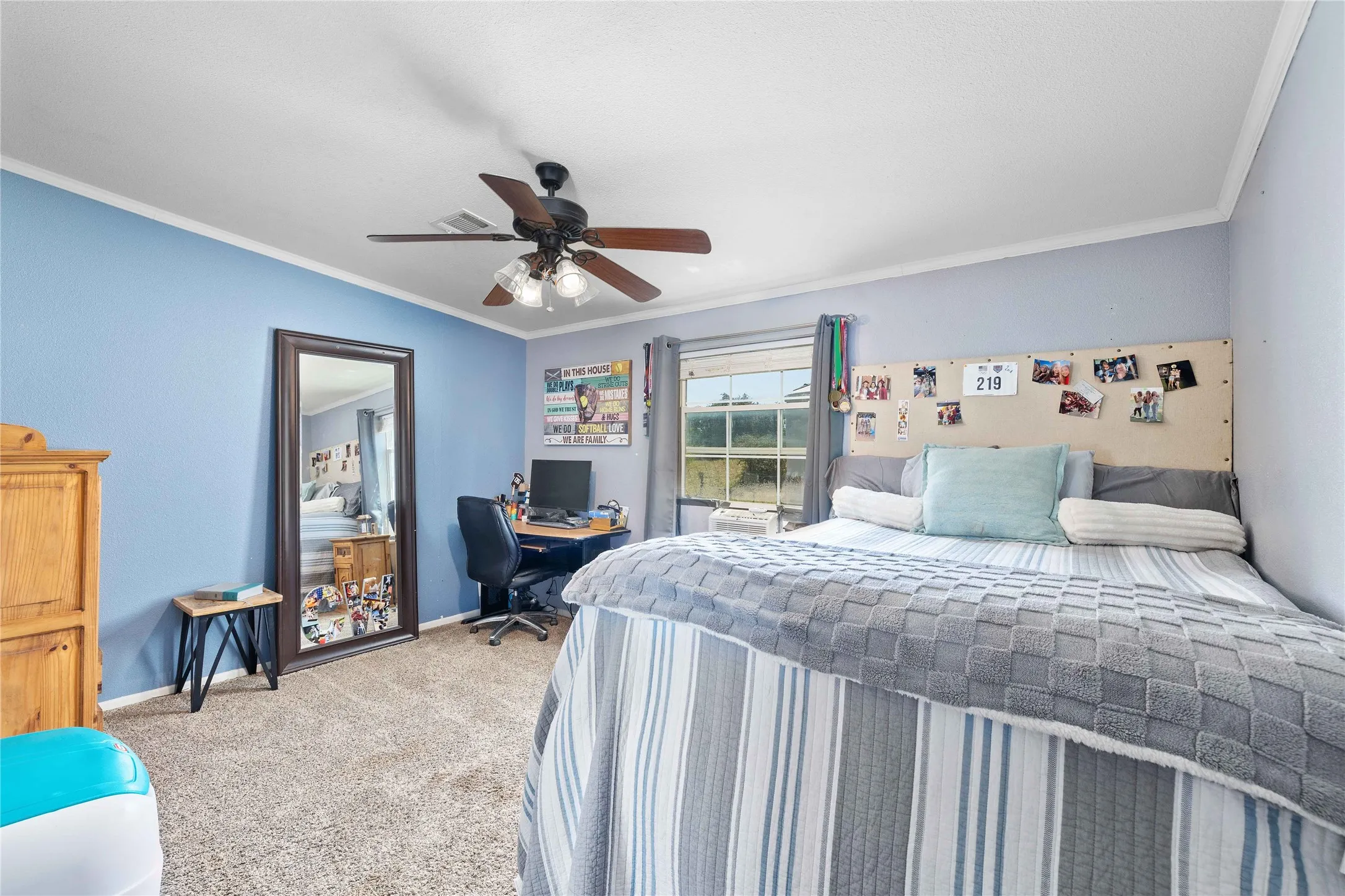 Carpeted bedroom with crown molding, a ceiling fan, and an office area