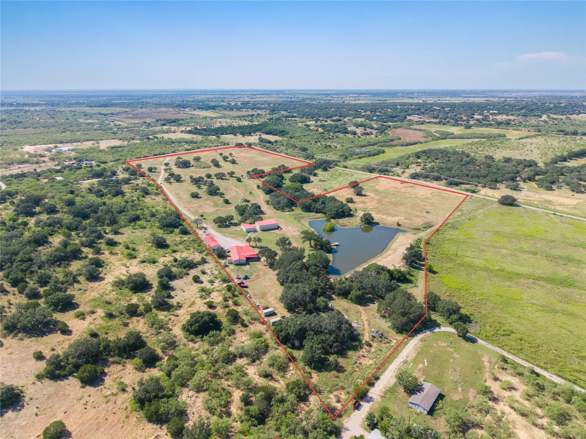 Aerial view of sparsely populated area with property boundaries highlighted and a nearby body of water