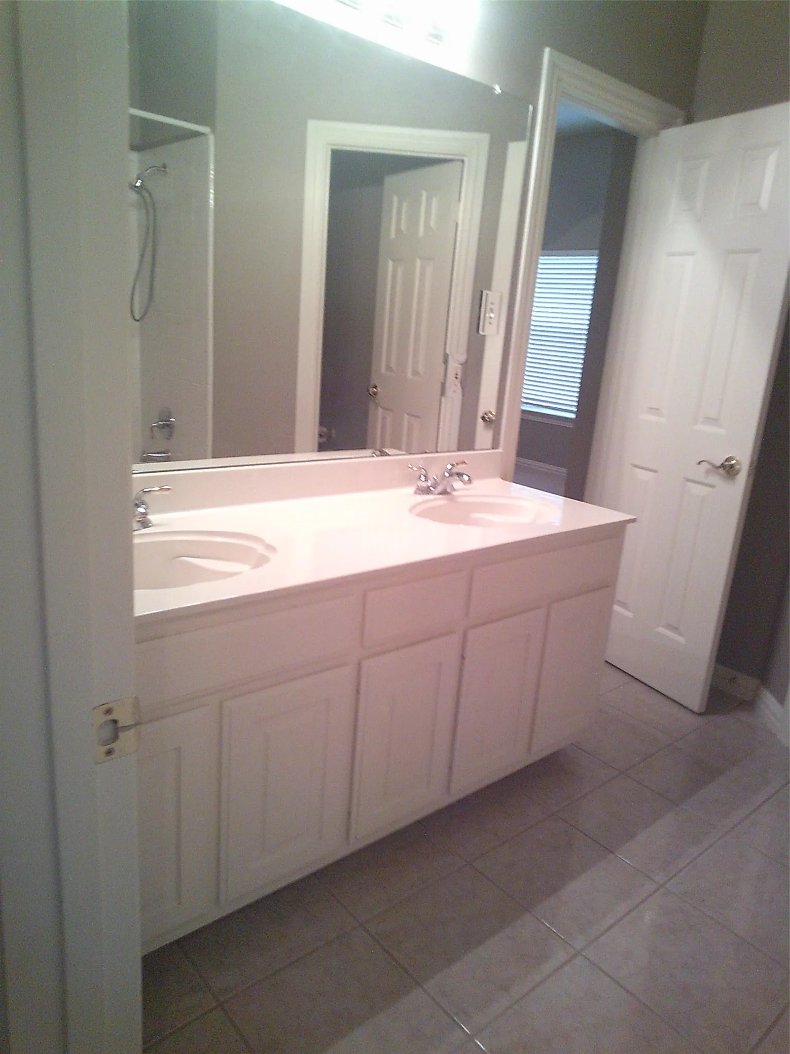 Bathroom with light tile patterned flooring, shower / bathtub combination, and double vanity