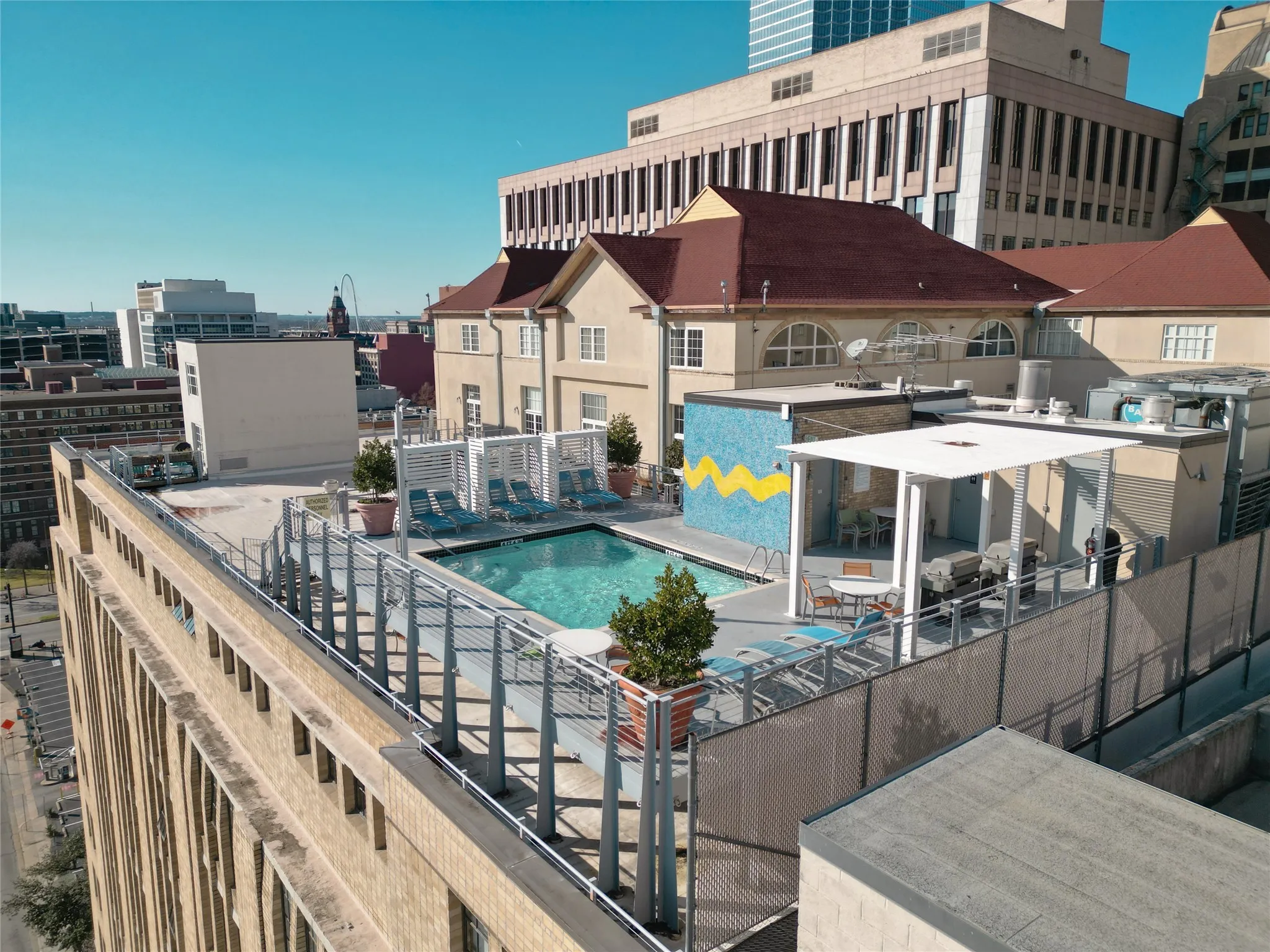 View of roof top pool with sitting areas and grills
