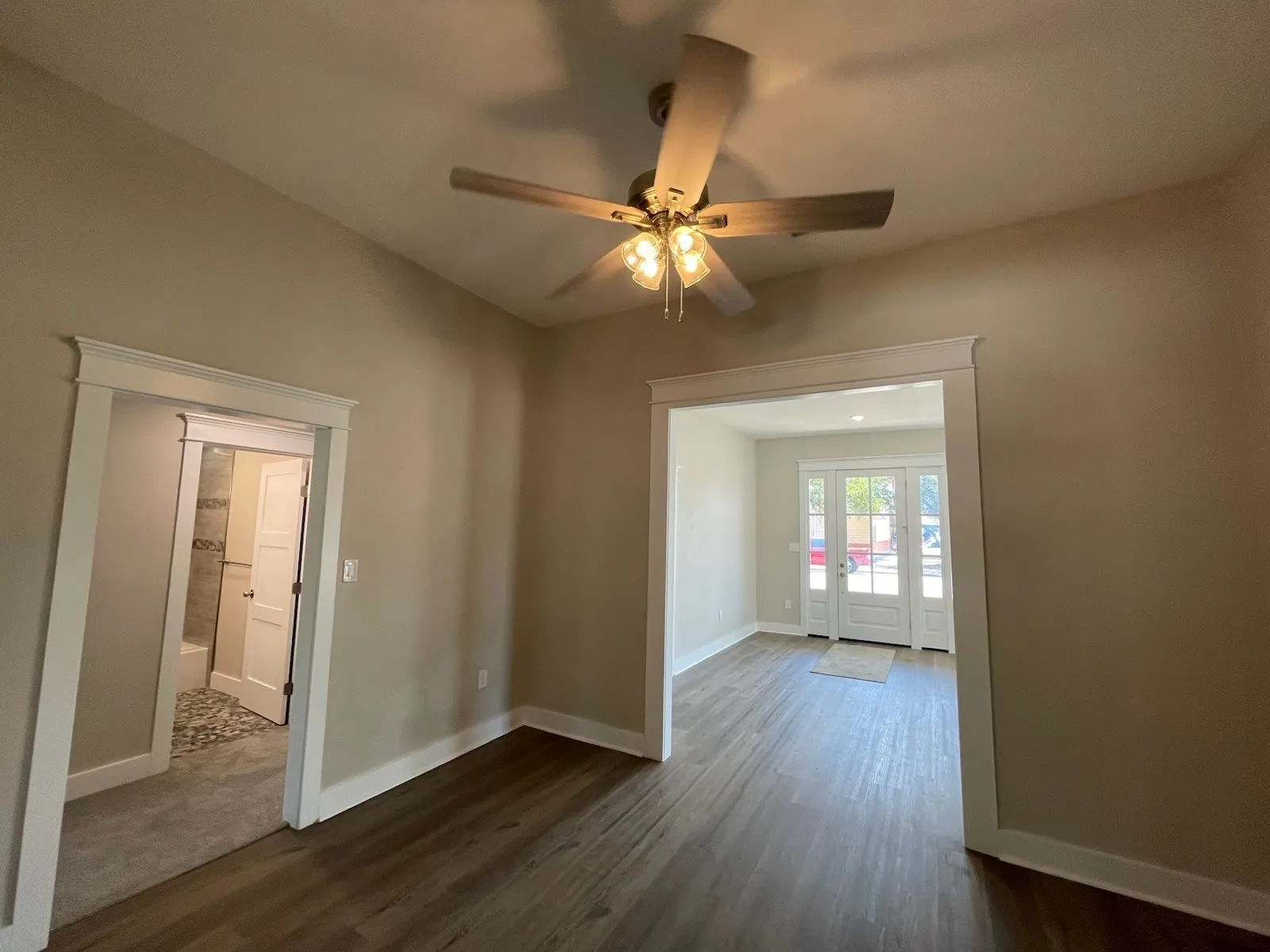 Spare room featuring dark wood-type flooring, ceiling fan, and french doors