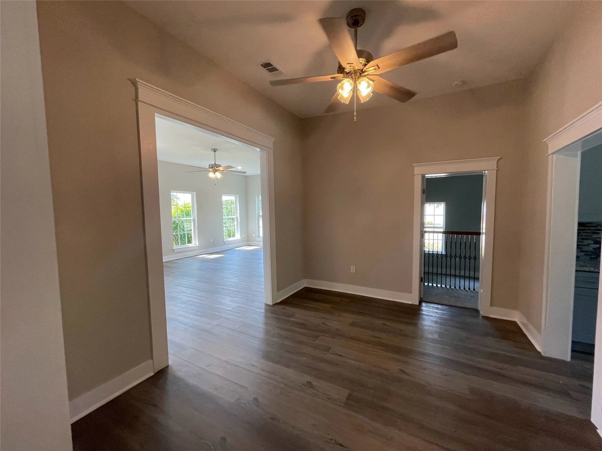 Empty room with ceiling fan and dark wood finished floors