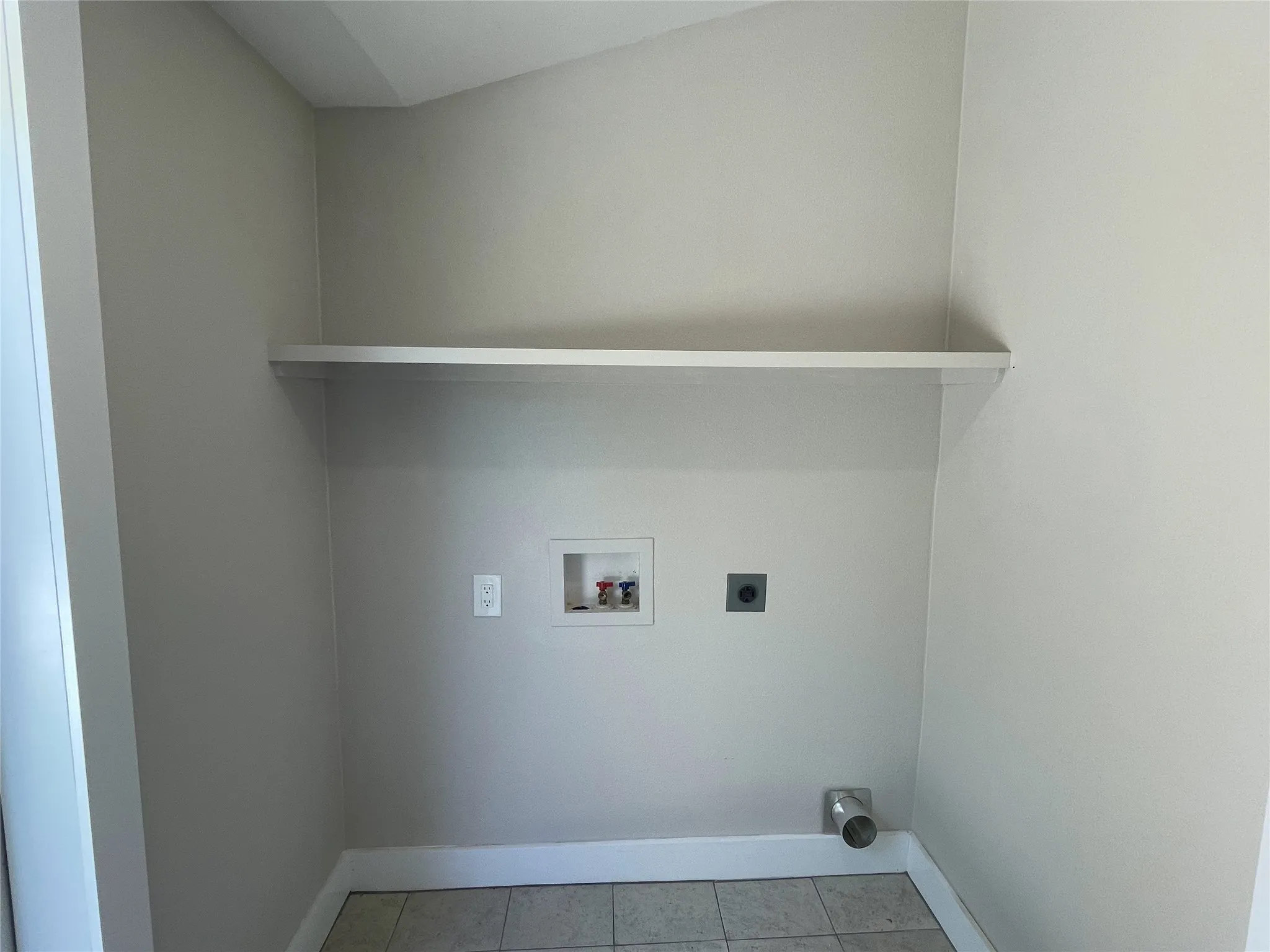 Washroom with washer hookup, light tile patterned floors, and electric dryer hookup