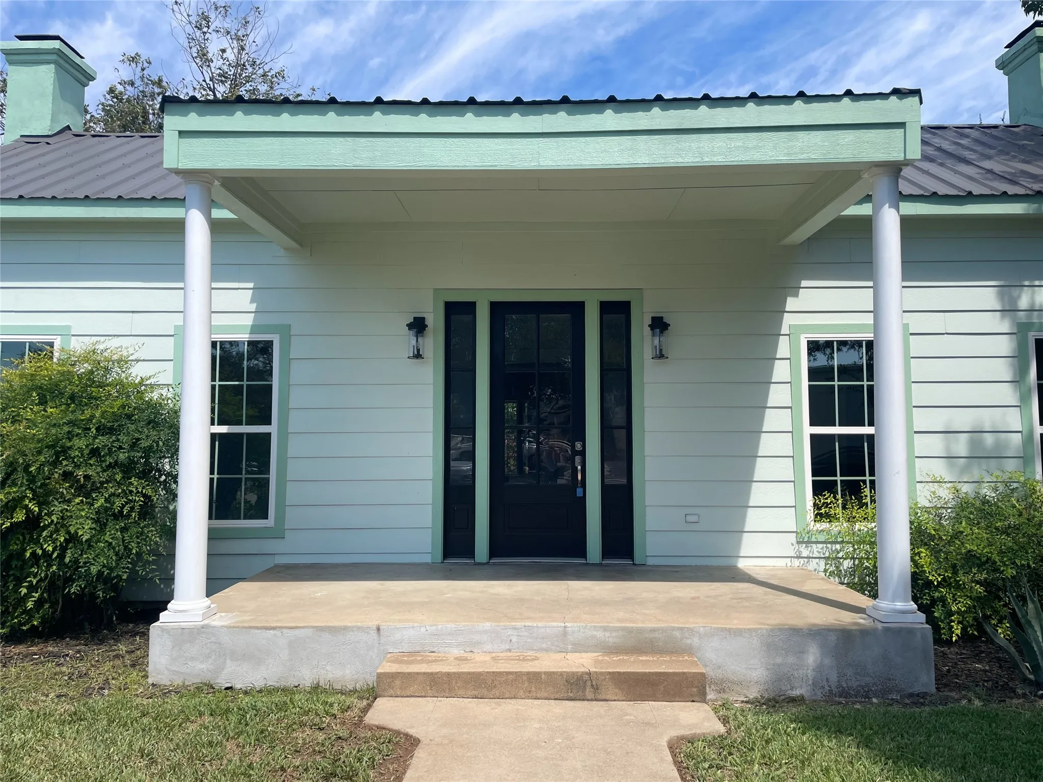 Entrance to property with a metal roof and covered porch