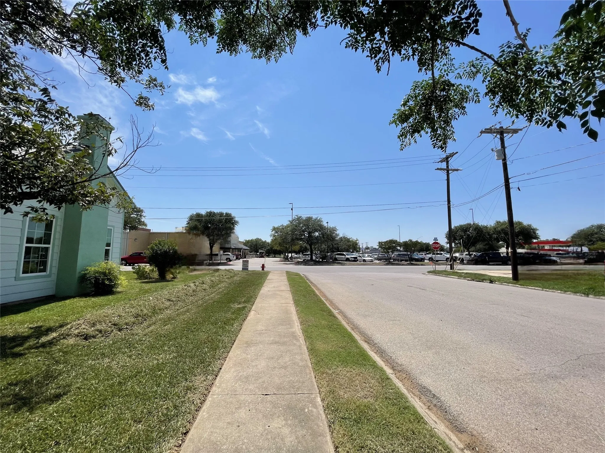 View of asphalt street with sidewalks, traffic signs, and curbs