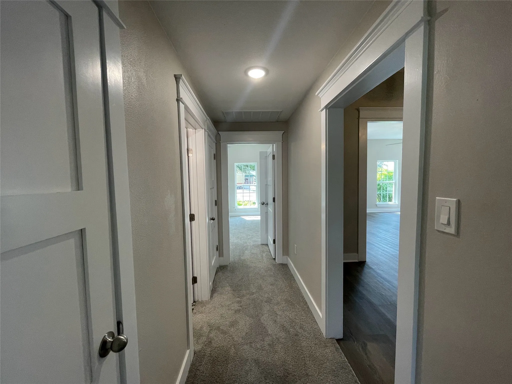 Corridor with carpet floors and a textured wall