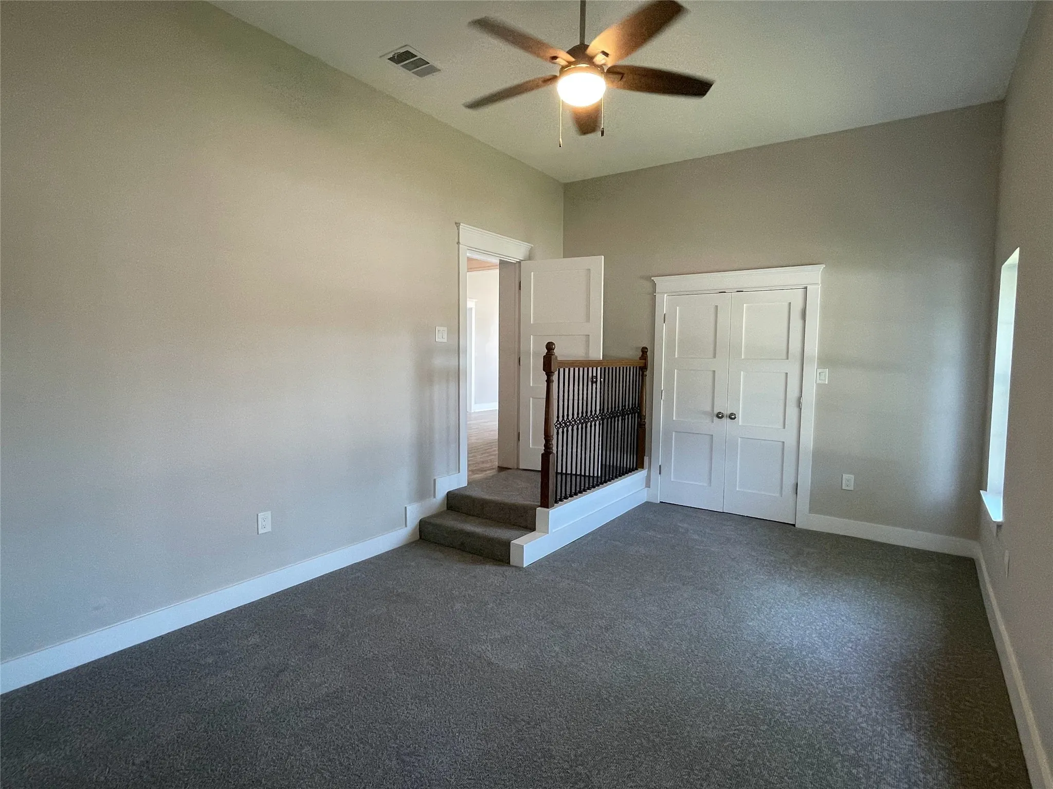 Unfurnished bedroom featuring dark colored carpet, ceiling fan, and a closet
