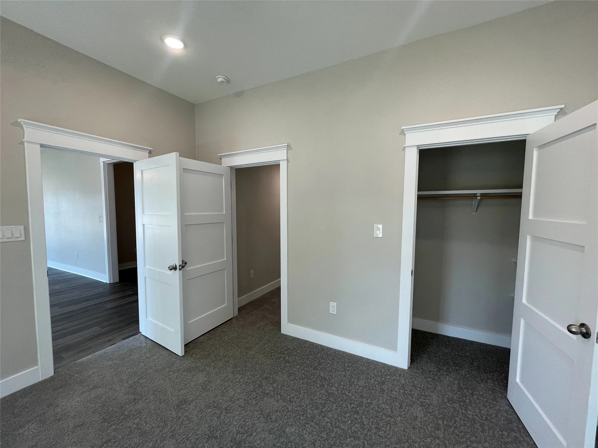 Unfurnished bedroom with dark carpet, a closet, and recessed lighting