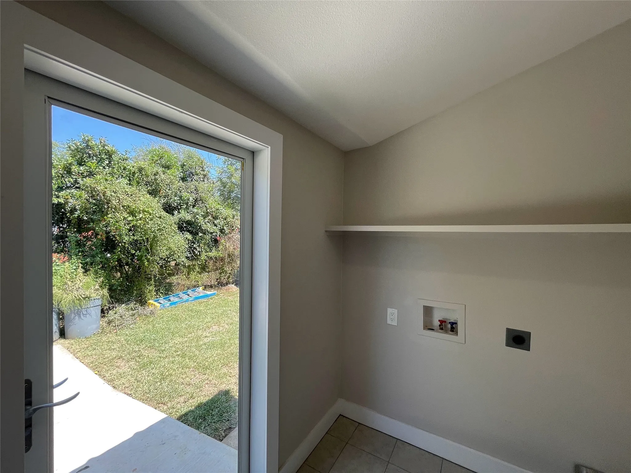 Washroom with washer hookup, light tile patterned floors, and electric dryer hookup