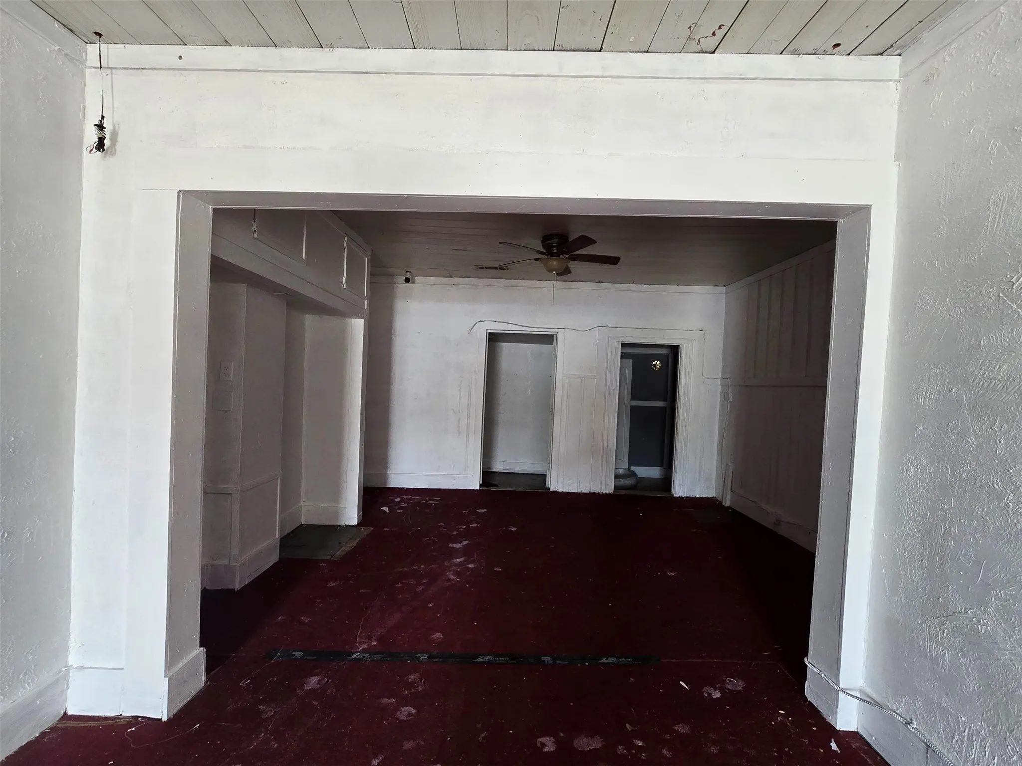 Unfurnished room featuring a textured wall, ceiling fan, and wooden ceiling