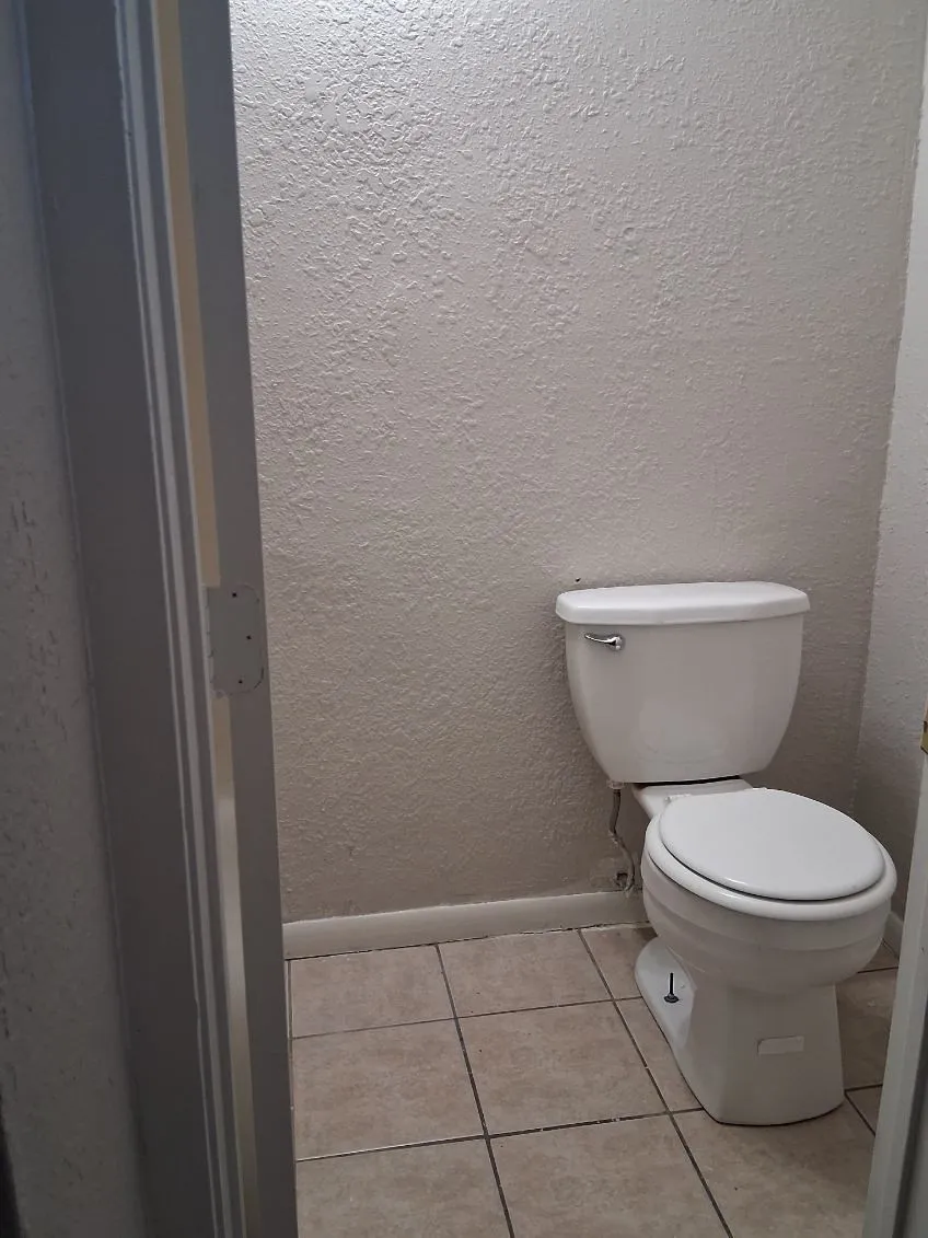 Bathroom with a textured wall and light tile patterned floors