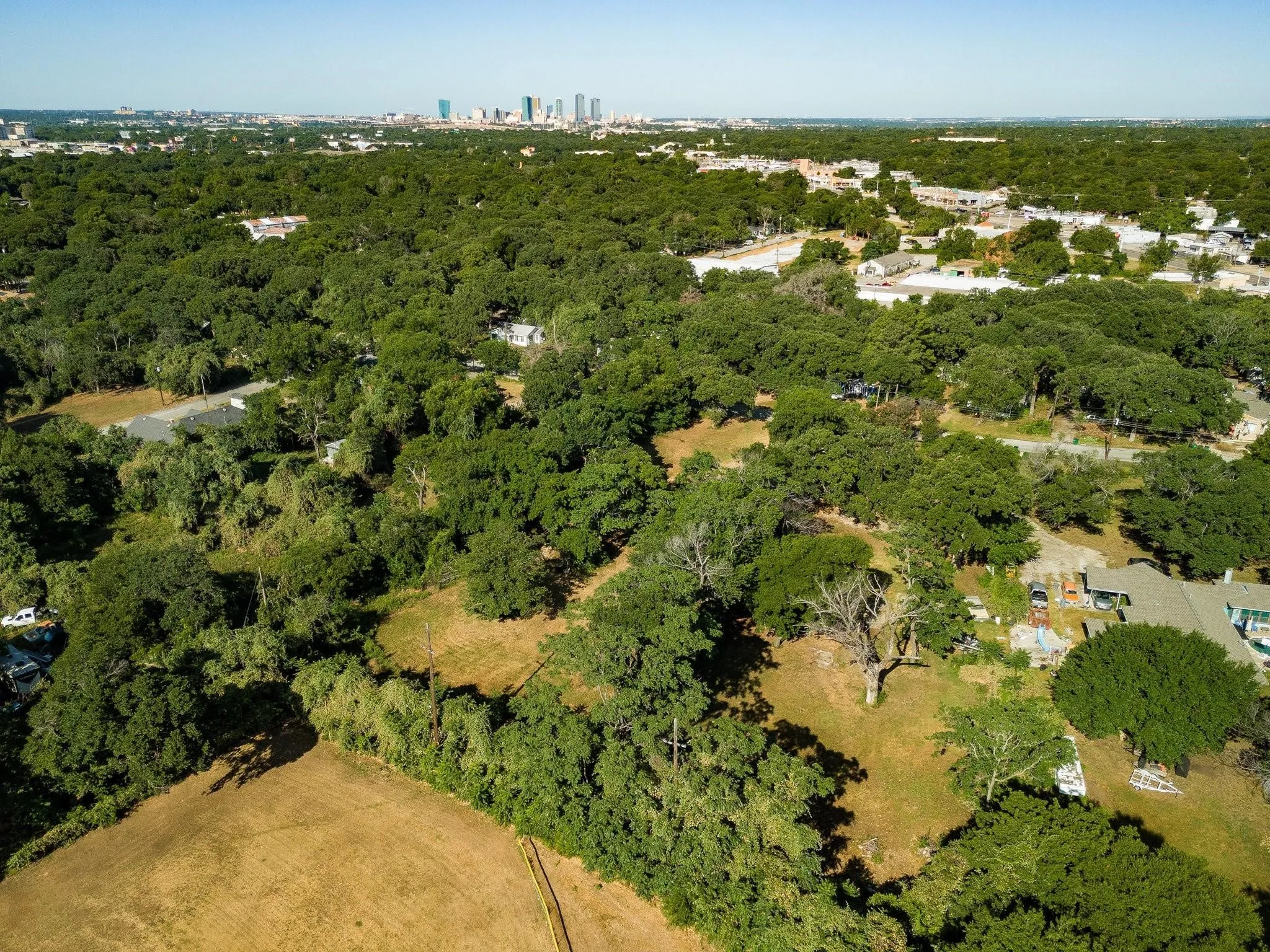 Aerial overview of property's location with a forest and city skyline