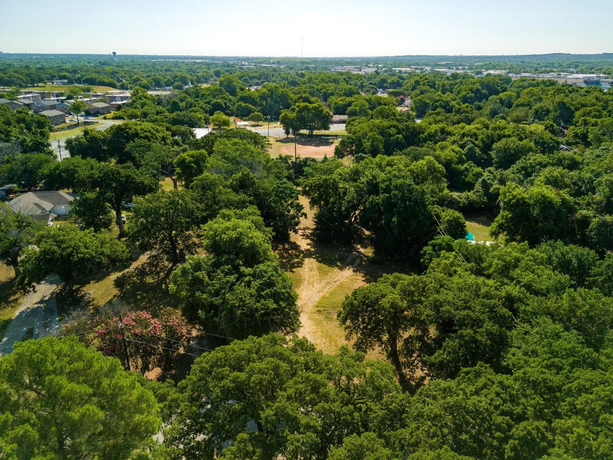 Aerial view of property and surrounding area with a heavily wooded area