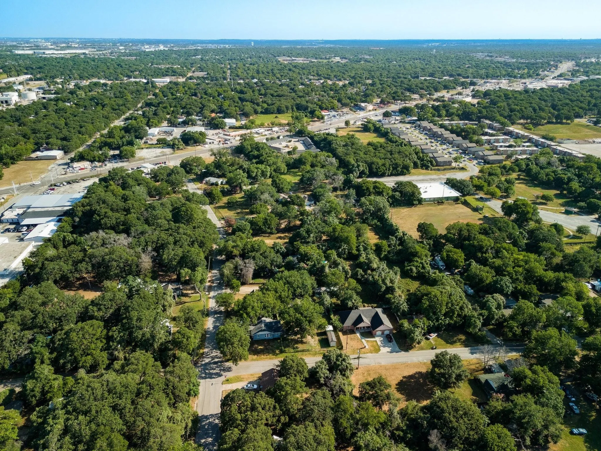 Aerial view of property and surrounding area featuring a tree filled landscape