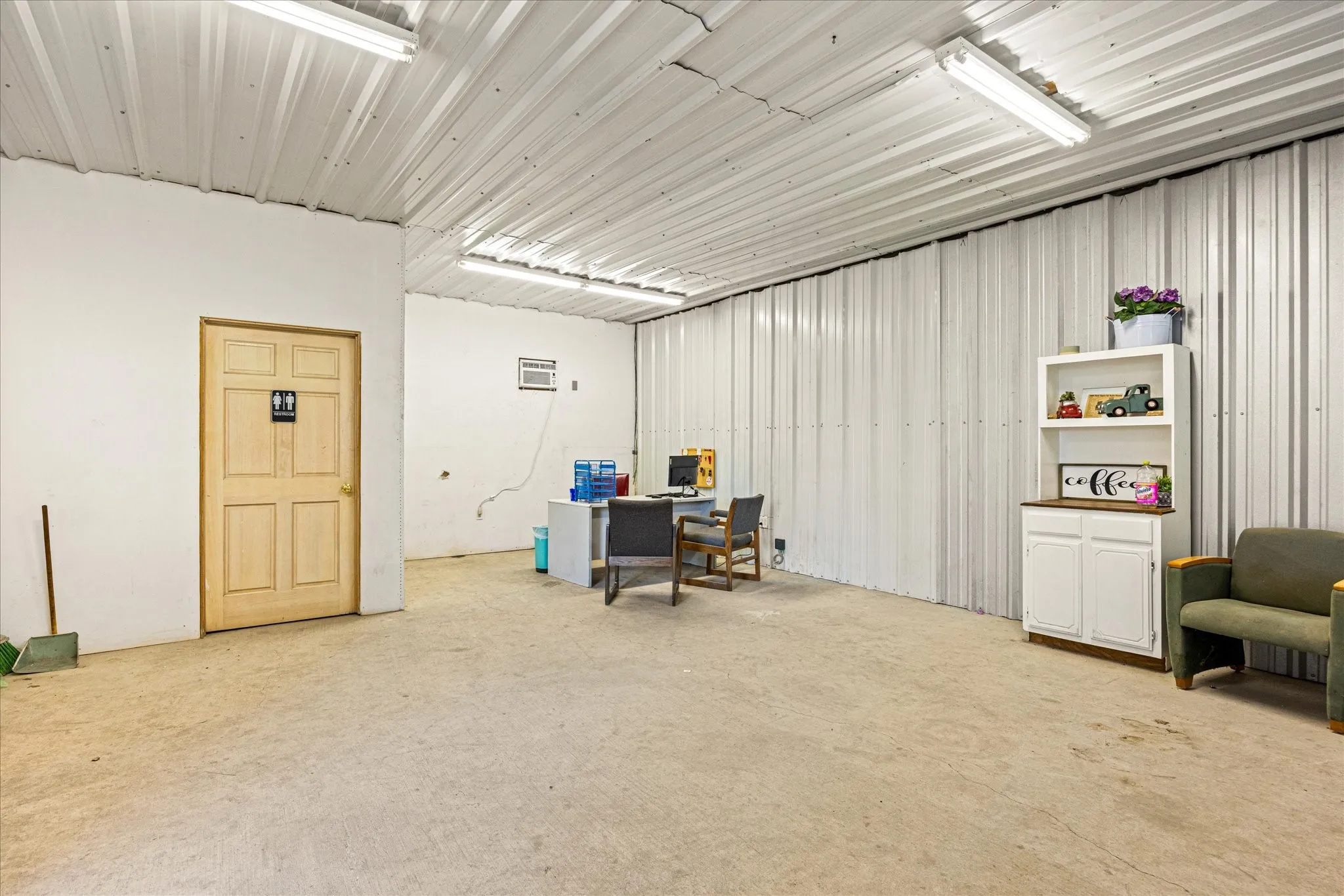 Office featuring metal wall and concrete flooring