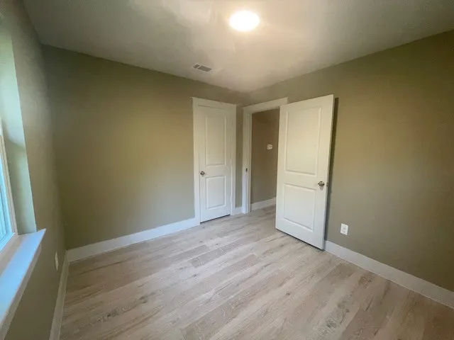 Unfurnished bedroom with light wood-type flooring and baseboards