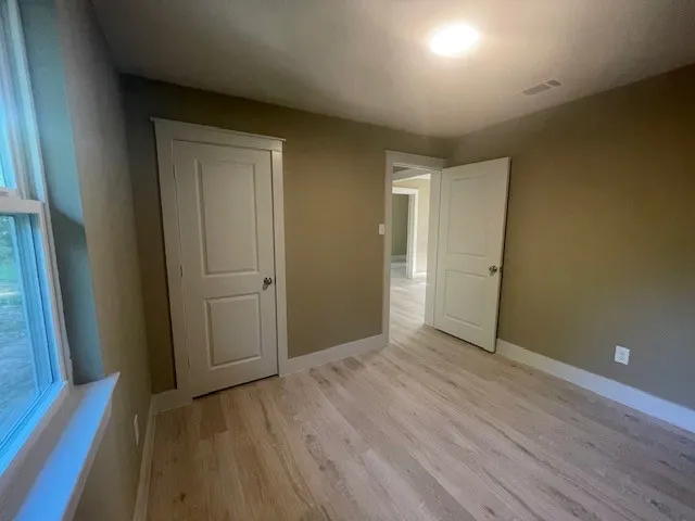 Unfurnished bedroom featuring light wood-style flooring and baseboards
