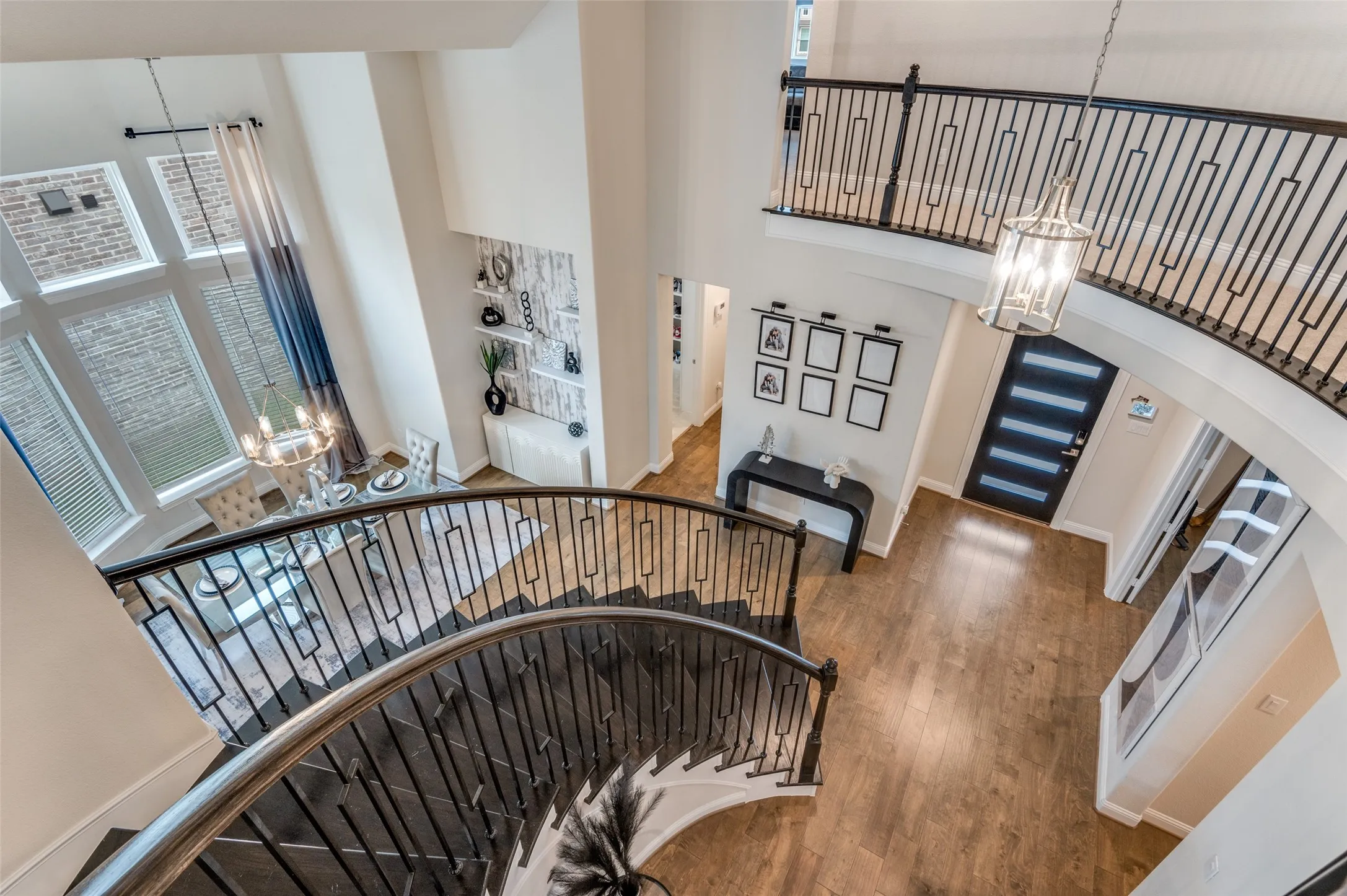 Staircase featuring a chandelier, a towering ceiling, wood finished floors, and arched walkways