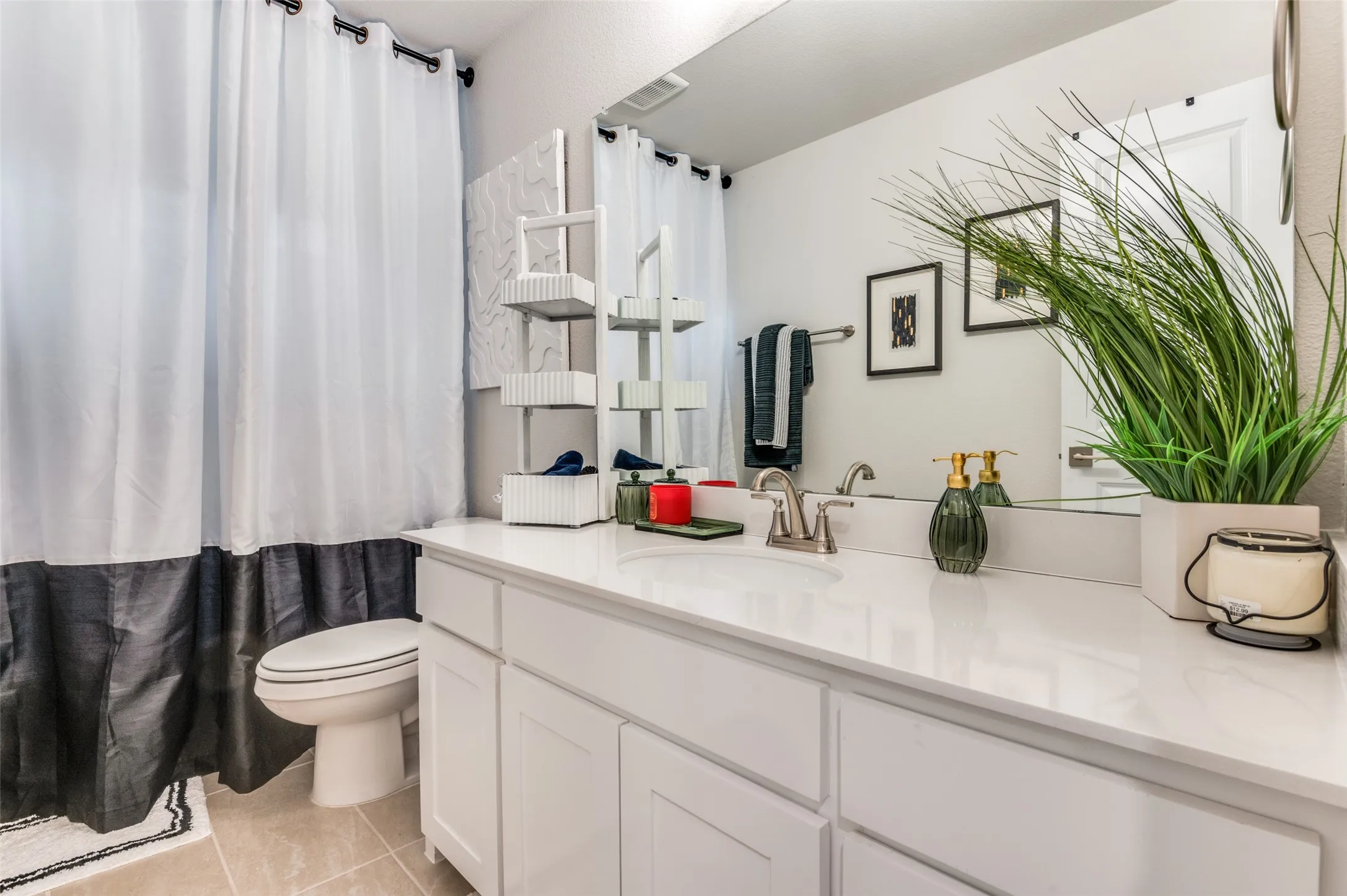 Bathroom featuring vanity, light tile patterned floors, and a shower with shower curtain