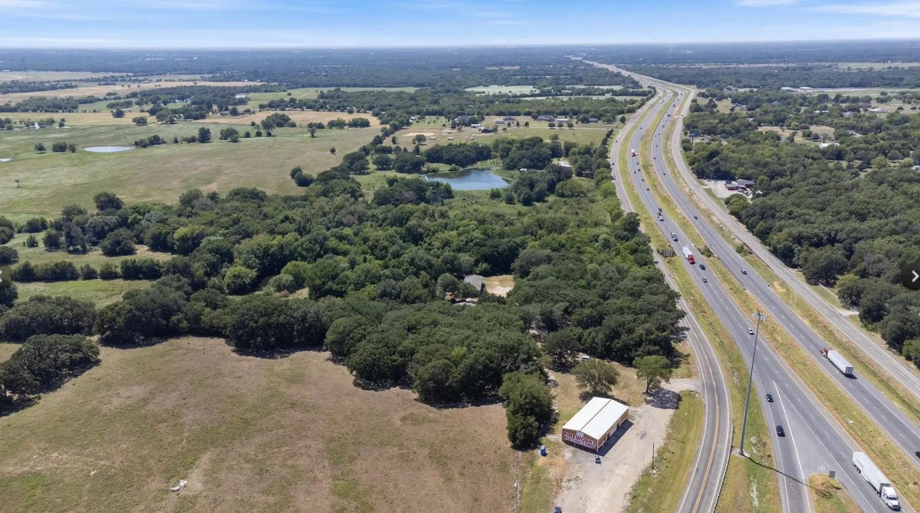Aerial view of property's location with a major roadway and a large body of water