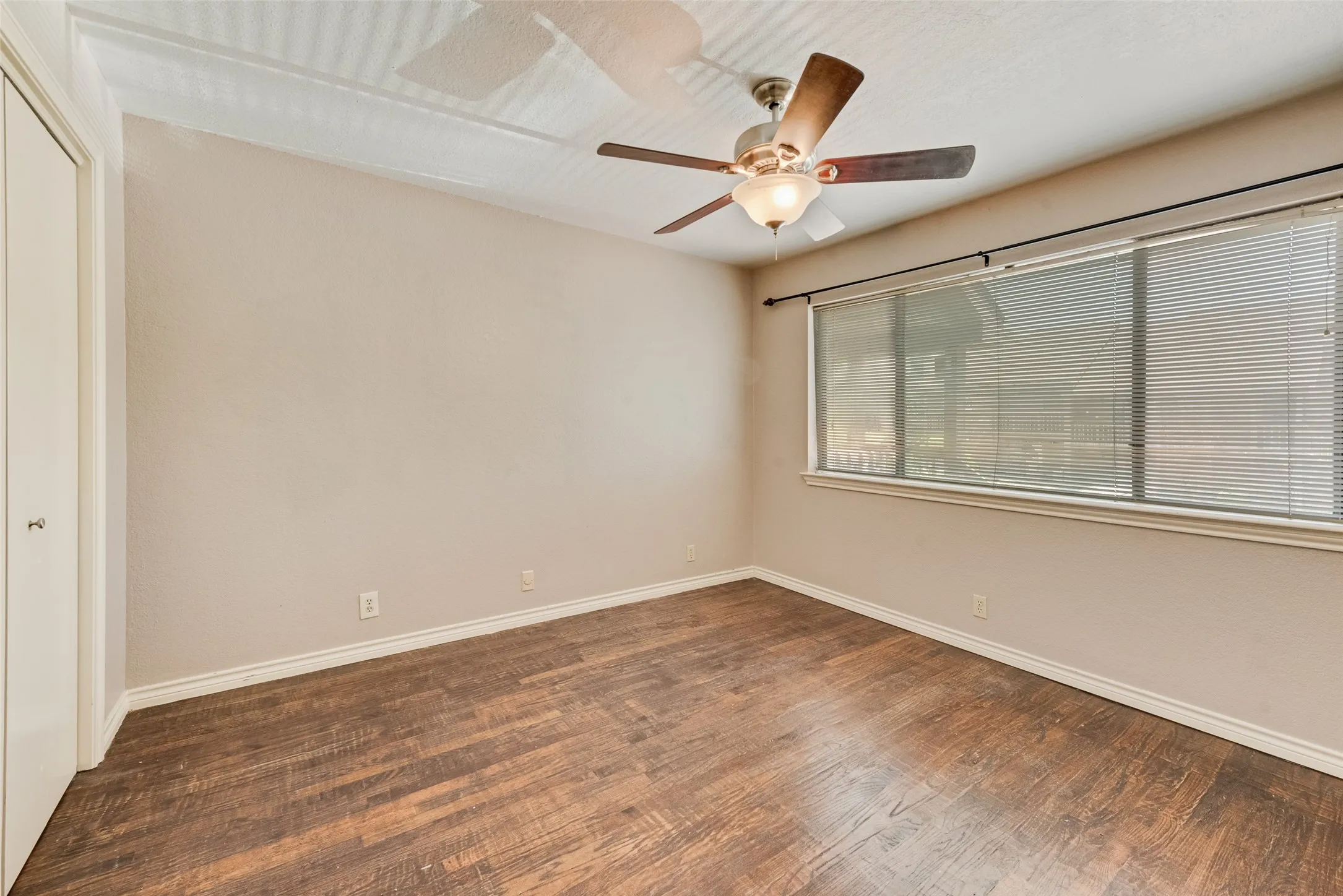 Unfurnished room featuring dark wood-style floors and baseboards