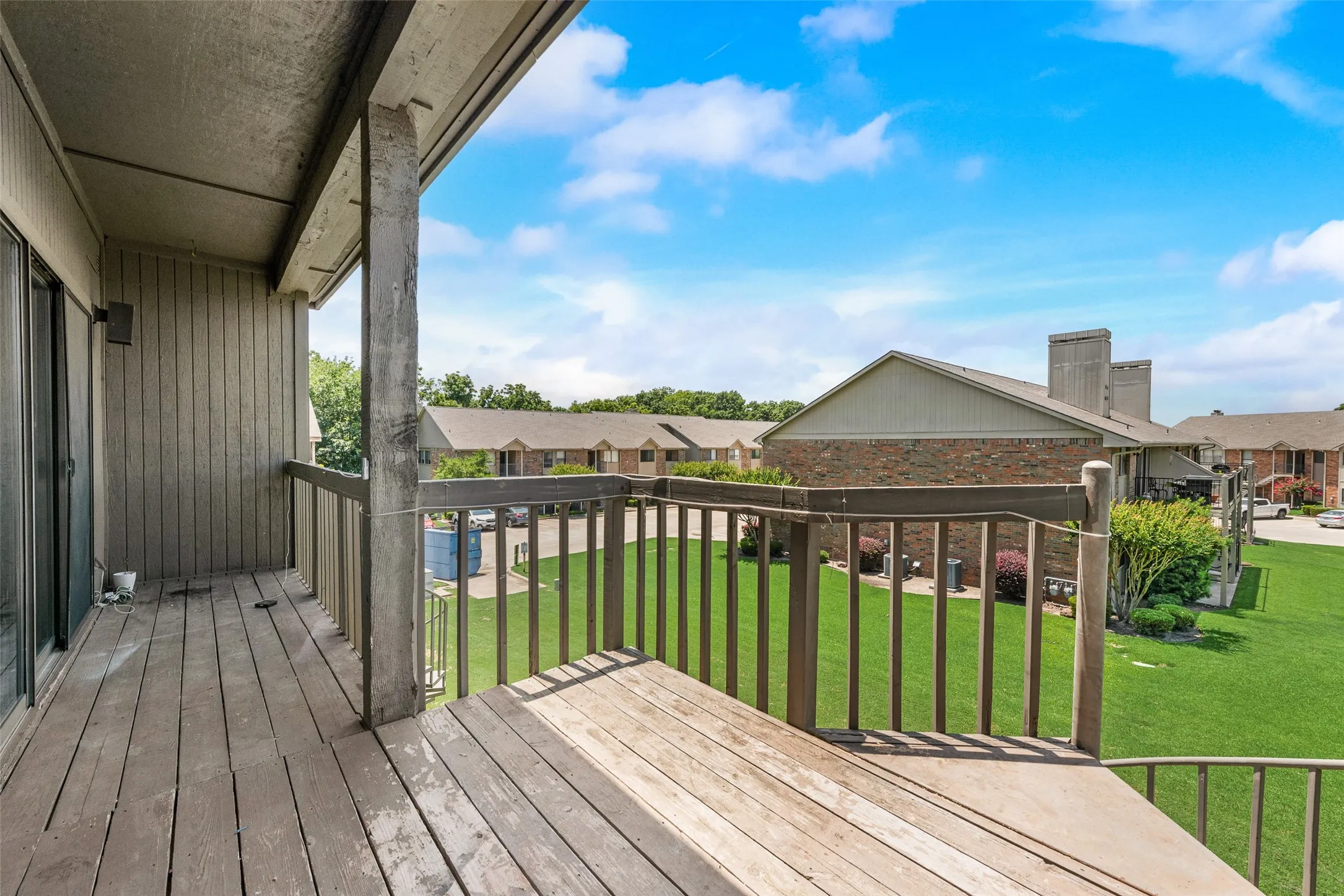 Wooden terrace with a residential view and a yard