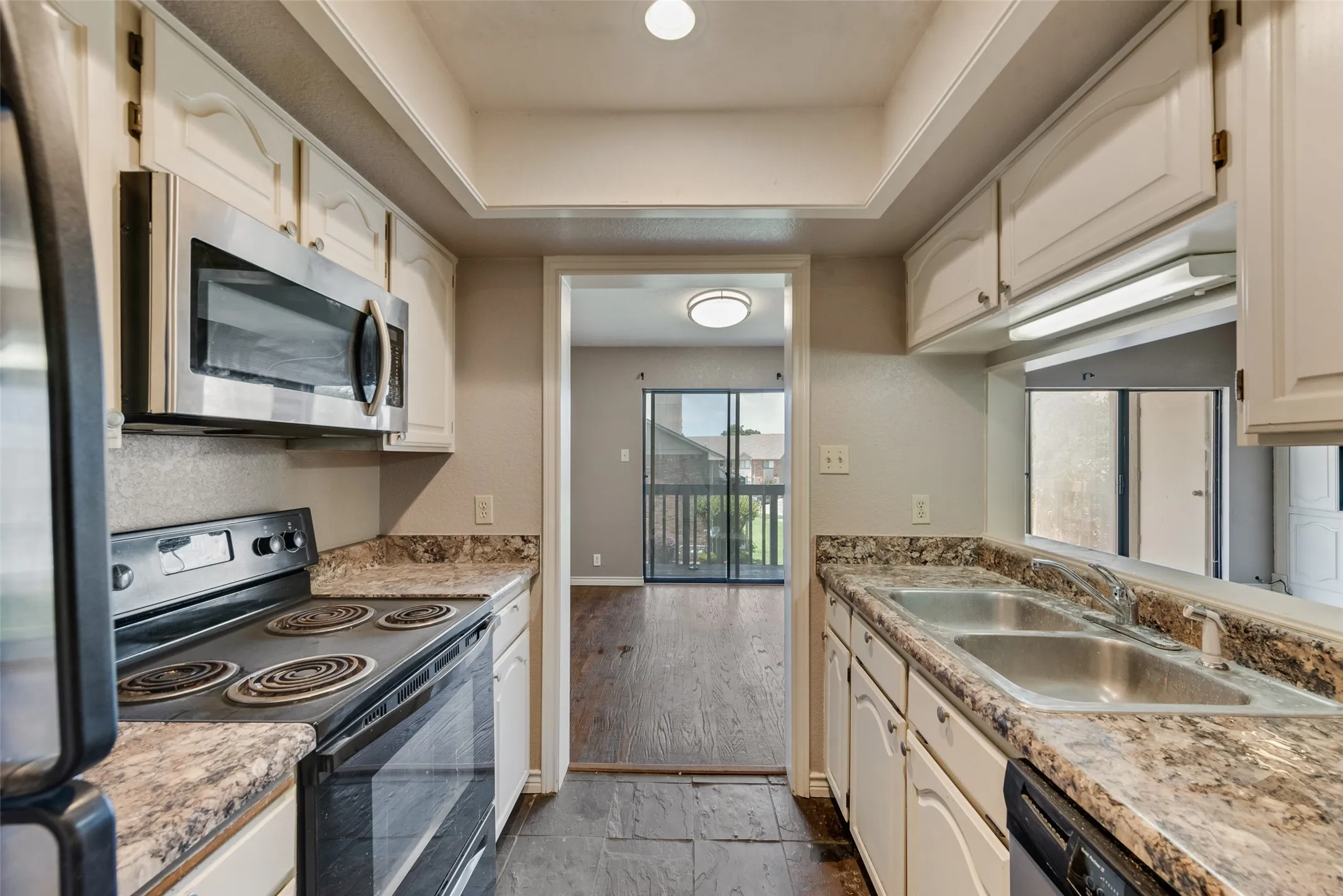 Kitchen featuring appliances with stainless steel finishes and a tray ceiling