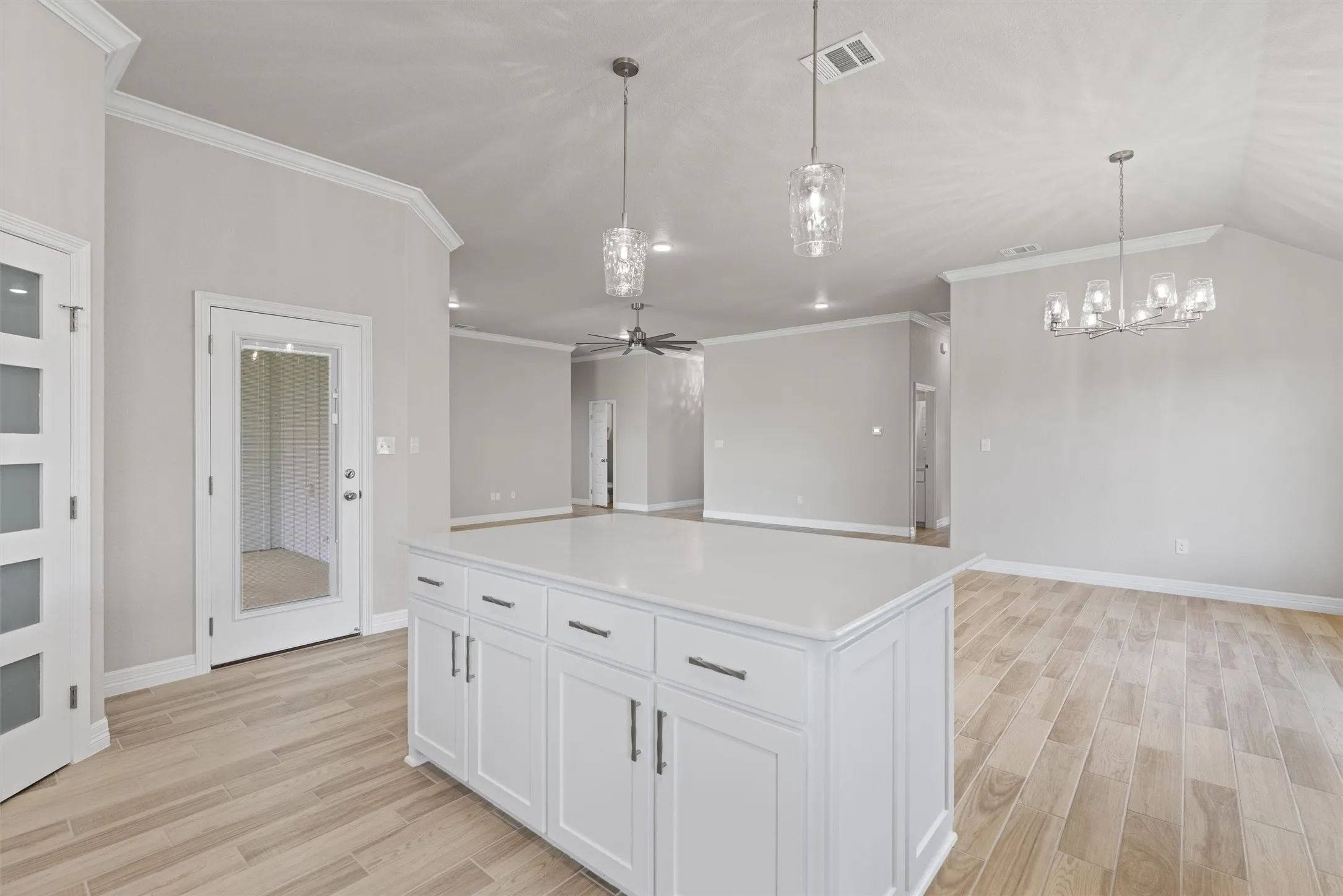 Kitchen island with white shaker-style cabinetry and a light-colored solid surface countertop