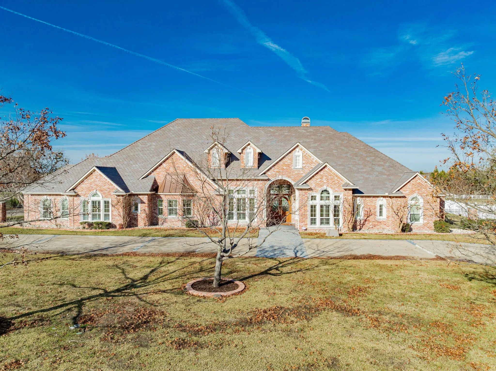 View of front of home featuring a chimney, a front yard, brick siding, and a shingled roof