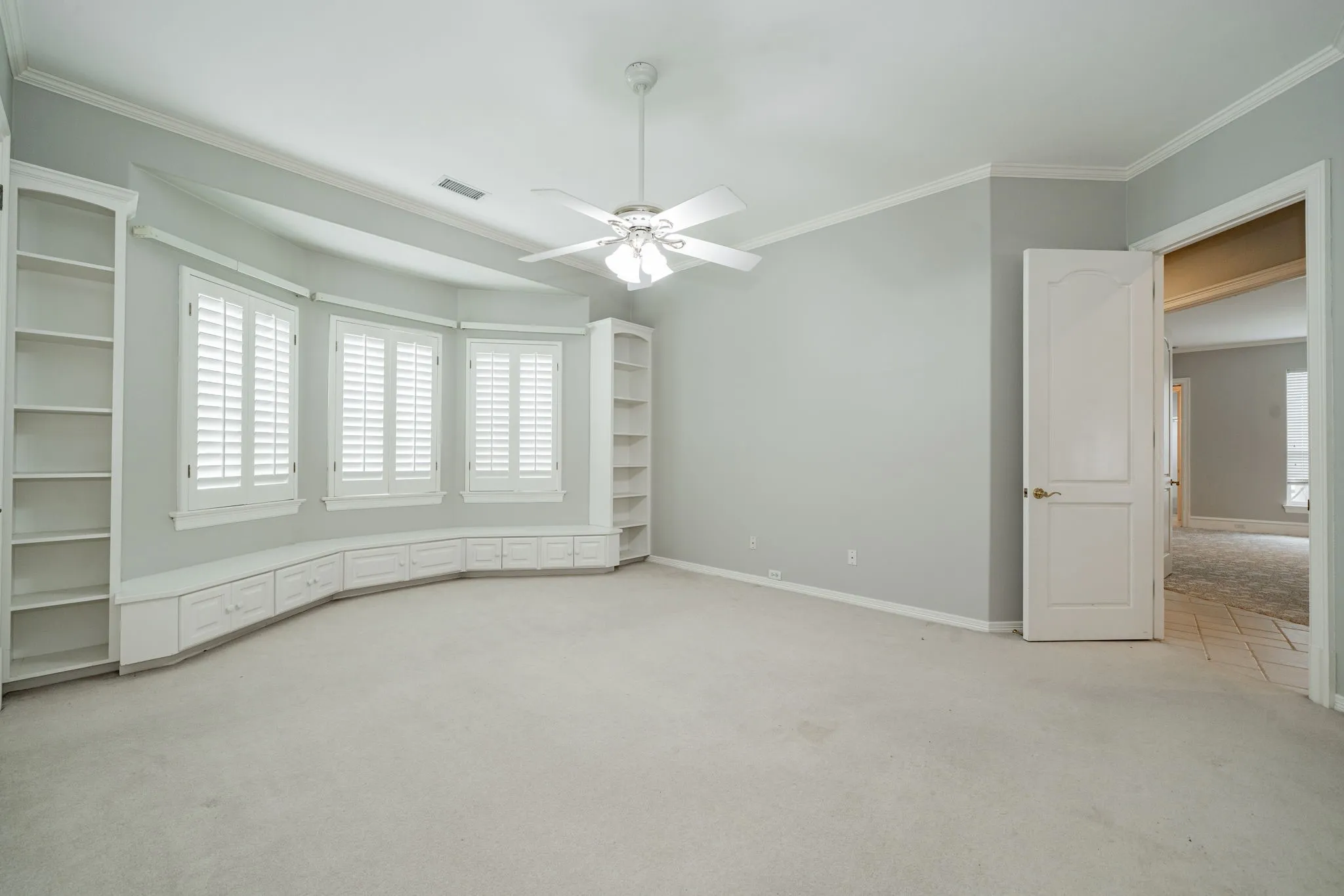 Unfurnished room featuring light carpet, crown molding, and ceiling fan