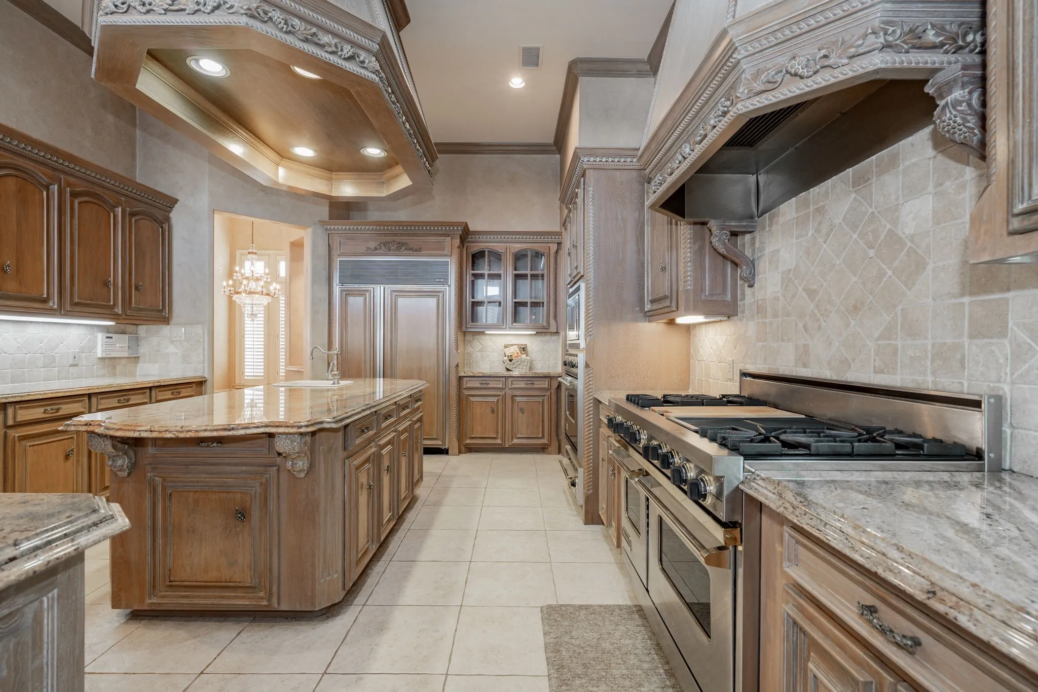 Kitchen with built in appliances, ornamental molding, light stone countertops, backsplash, and recessed lighting