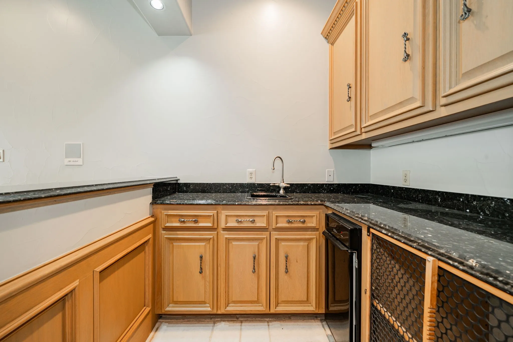 Kitchen featuring dark stone counters and light tile patterned flooring