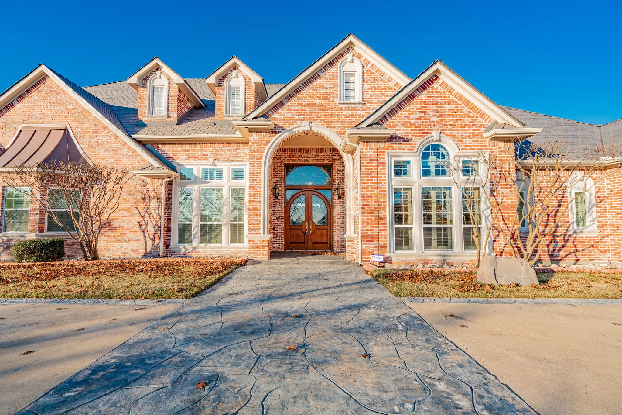 View of front of property with brick siding and roof with shingles