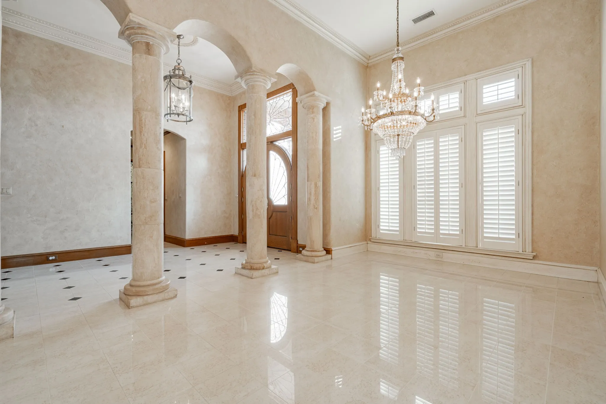 Entrance foyer featuring arched walkways, ornate columns, a chandelier, a towering ceiling, and ornamental​​‌​​​​‌​​‌‌​‌‌​​​‌‌​‌​‌​‌​​​‌​​ molding