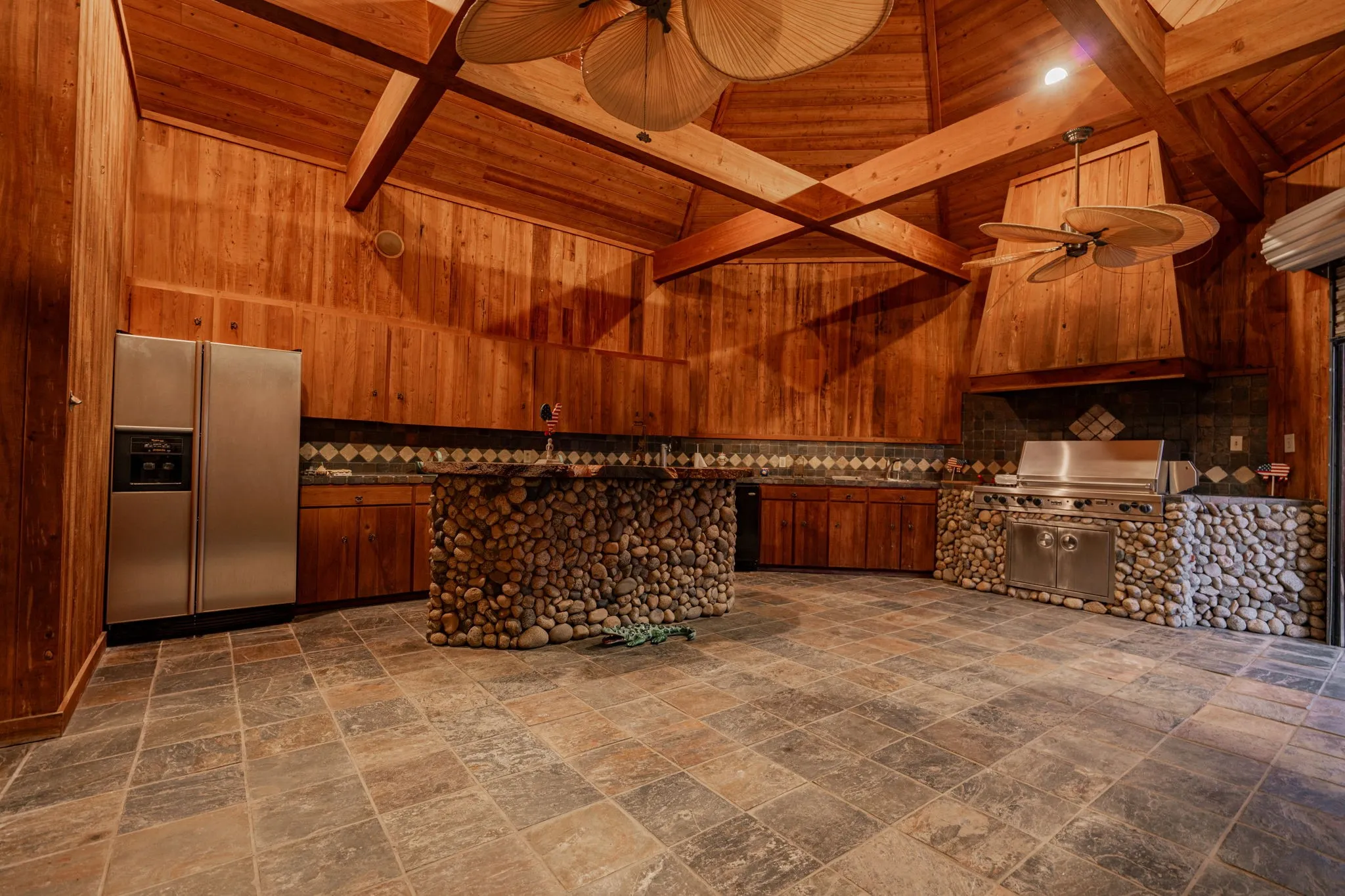Kitchen with high vaulted ceiling, a wooden ceiling with exposed beams, a ceiling fan, fridge with ice dispenser, and decorative backsplash