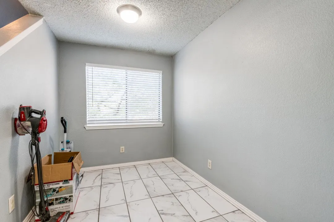 Unfurnished room with baseboards, a textured ceiling, and marble finish floor