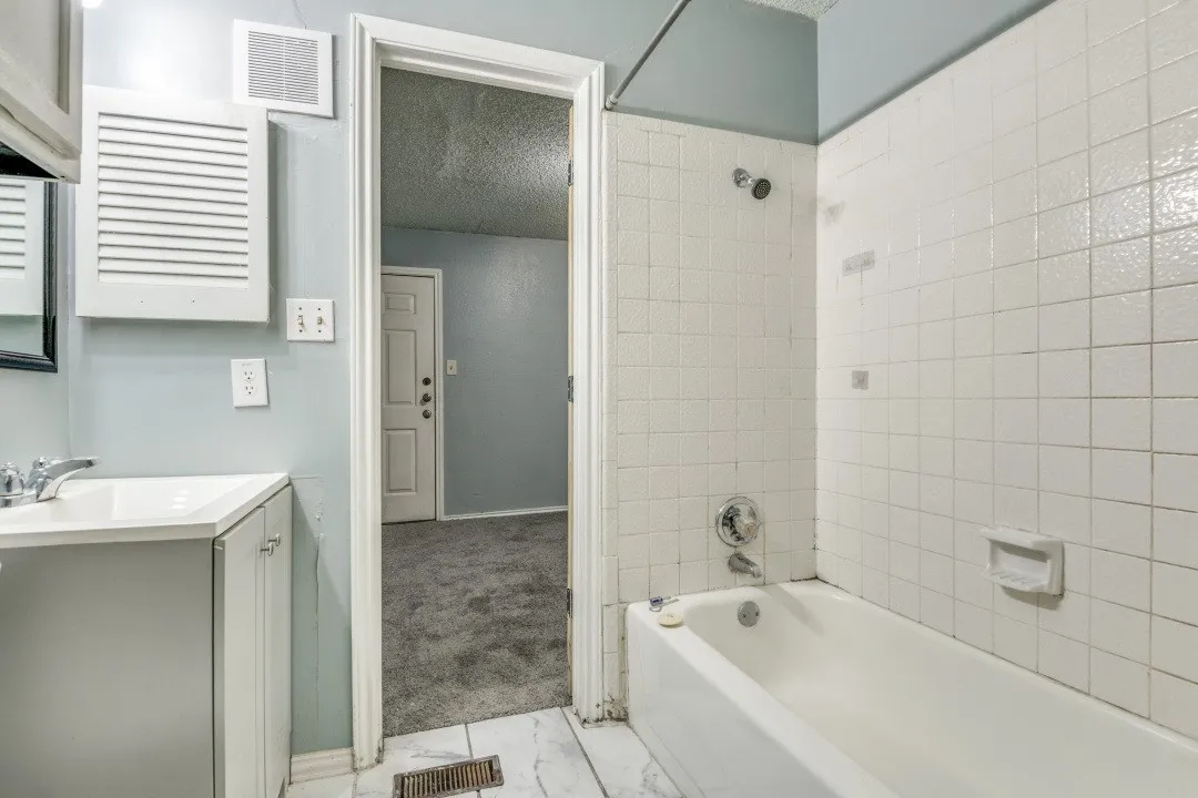 Full bathroom featuring visible vents, marble finish floor, vanity, and bathing tub / shower combination