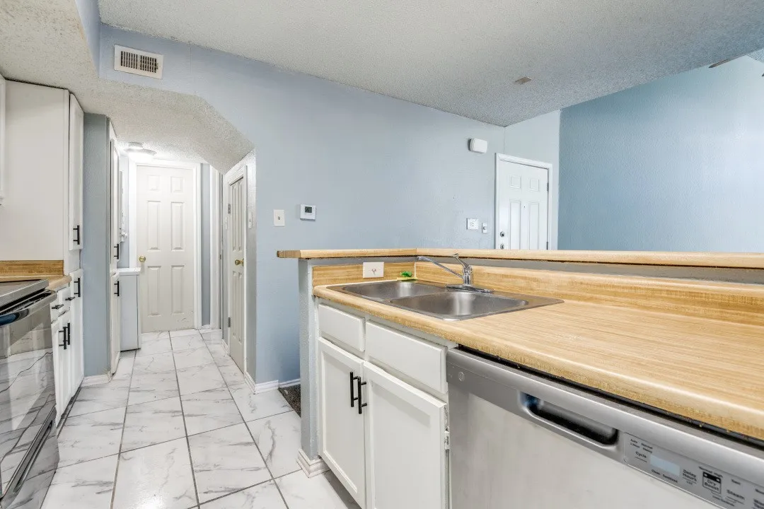 Kitchen with visible vents, stainless steel dishwasher, electric range, marble finish floor, and a sink