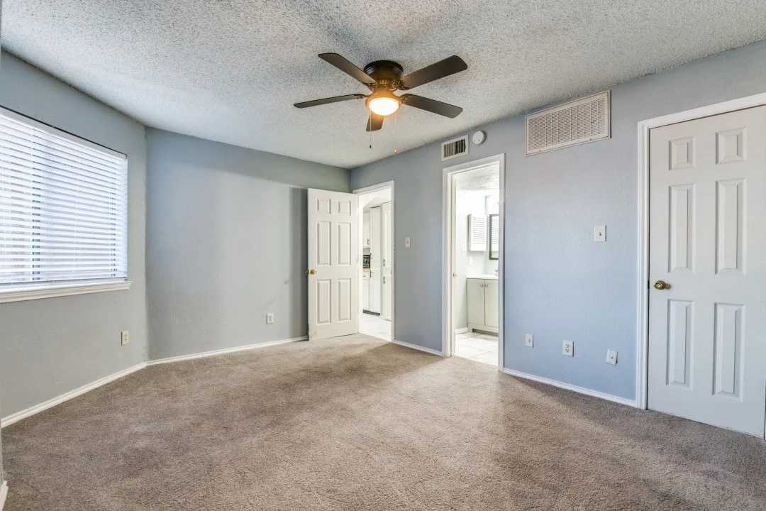 Unfurnished bedroom featuring visible vents, carpet floors, a textured ceiling, and ensuite bathroom