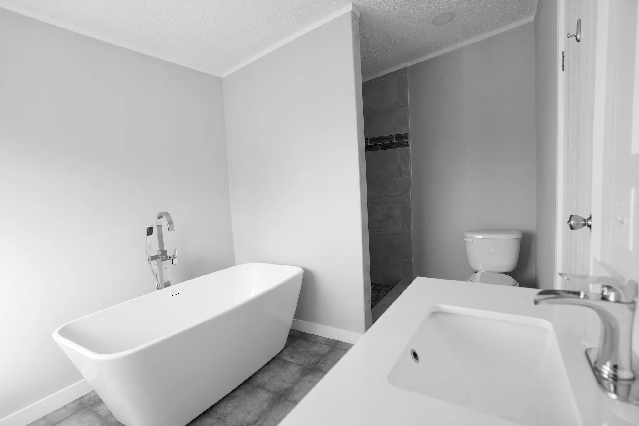 Bathroom featuring a freestanding bath, tiled shower, and a textured ceiling